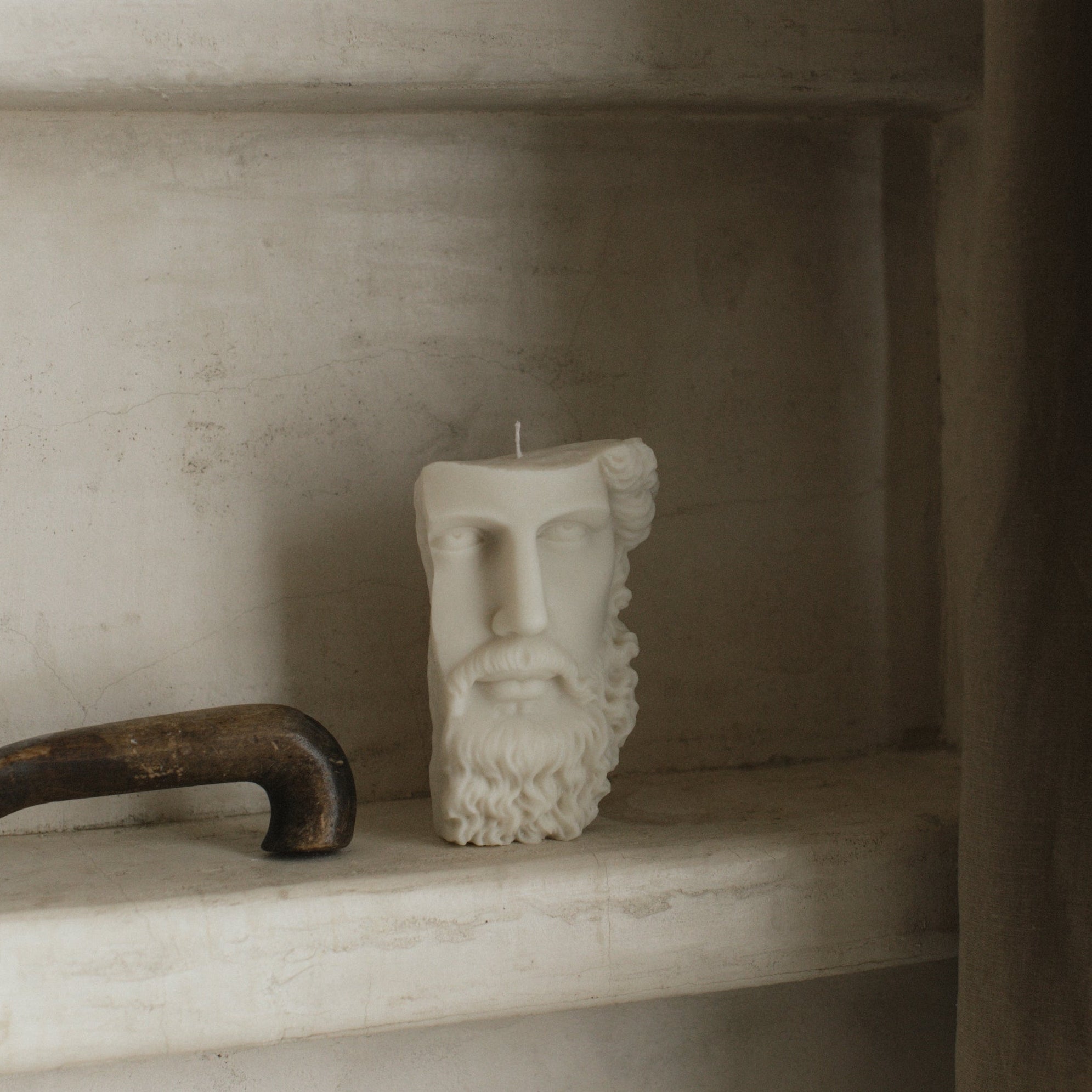Close-up detail of handmade Greek face sculptural candle showing smooth soy wax texture and artistic features