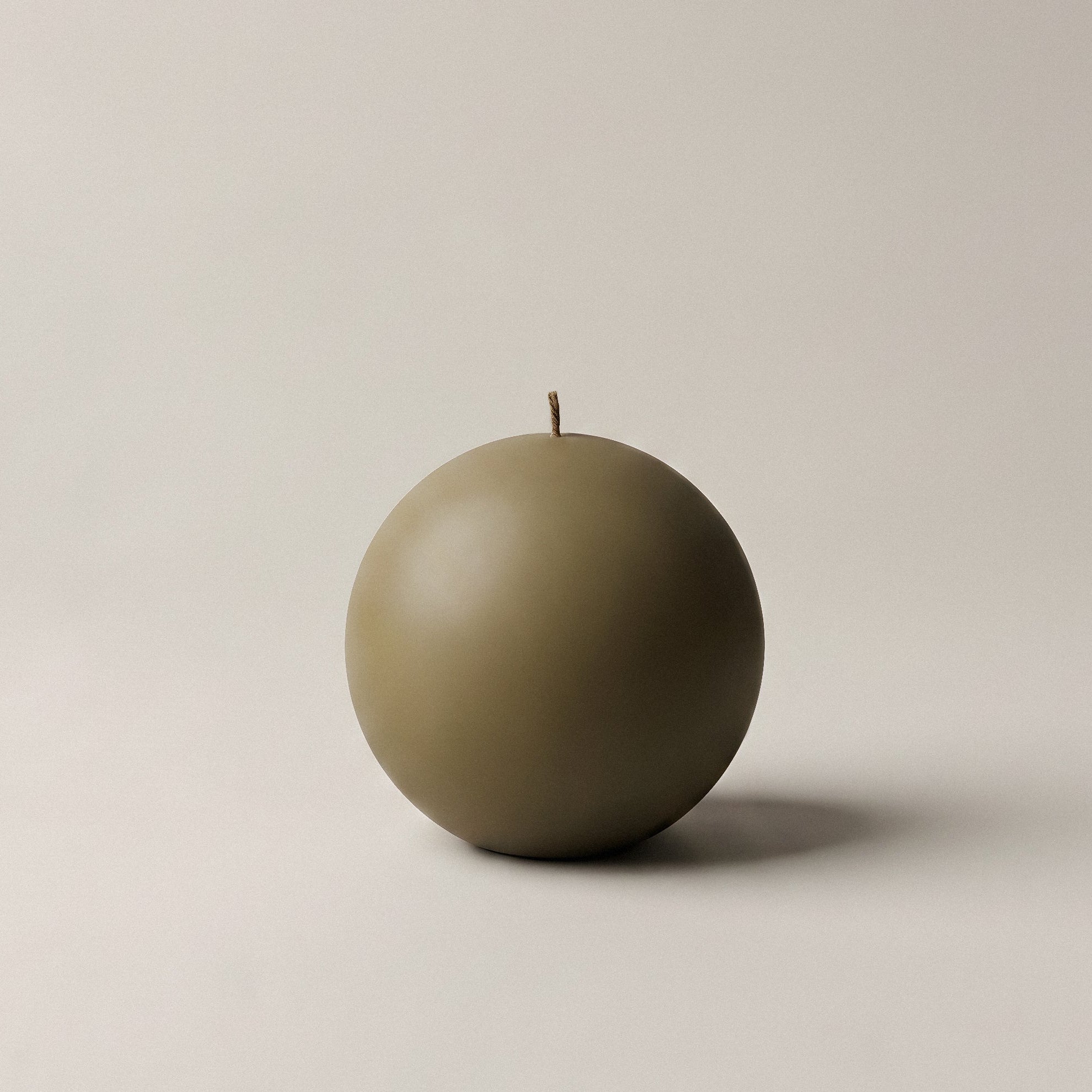 Handmade unscented sphere candle detail showing smooth soy wax texture and sculptural round form on neutral surface