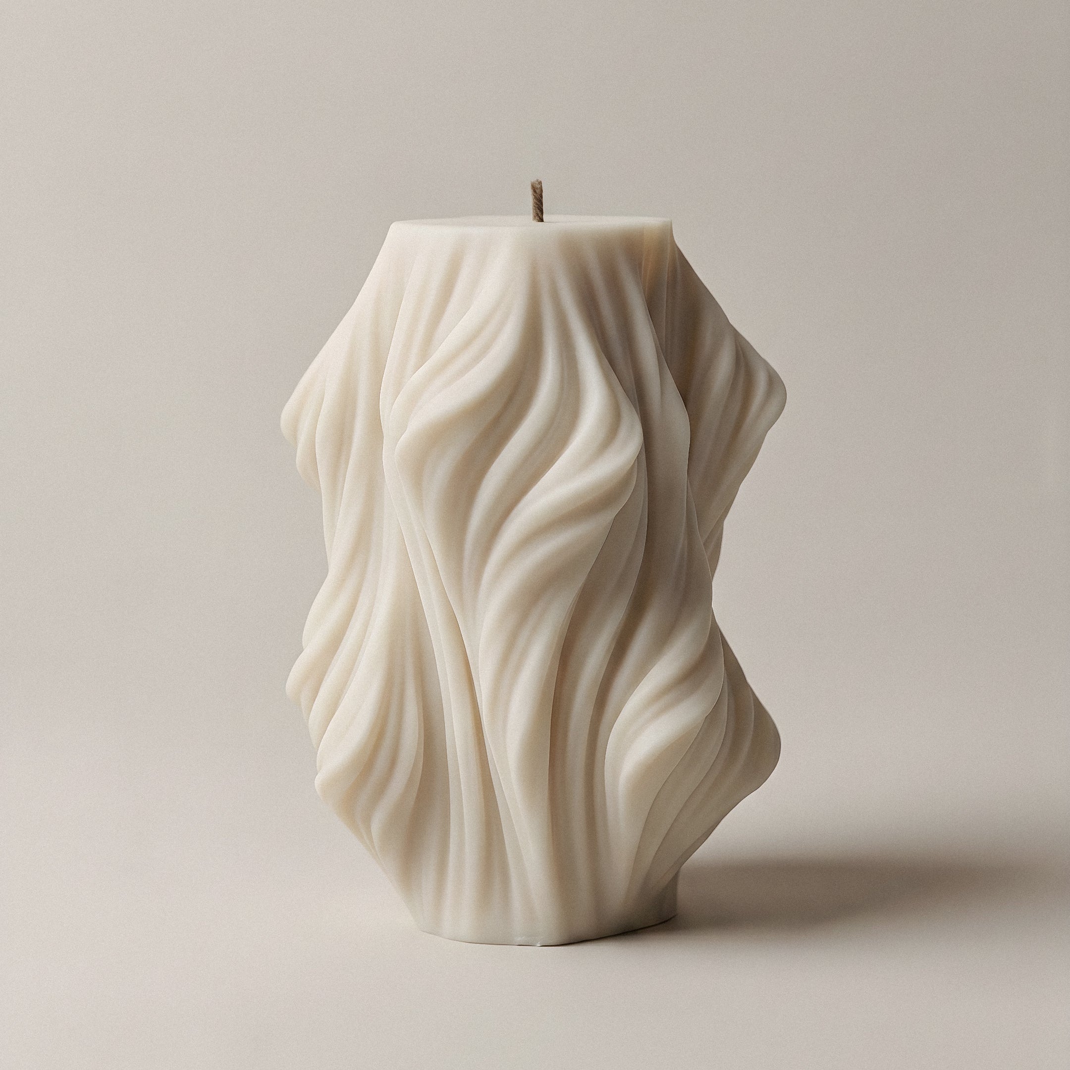 Close-up detail of handmade sculptural candle showcasing flowing wave texture in premium soy wax