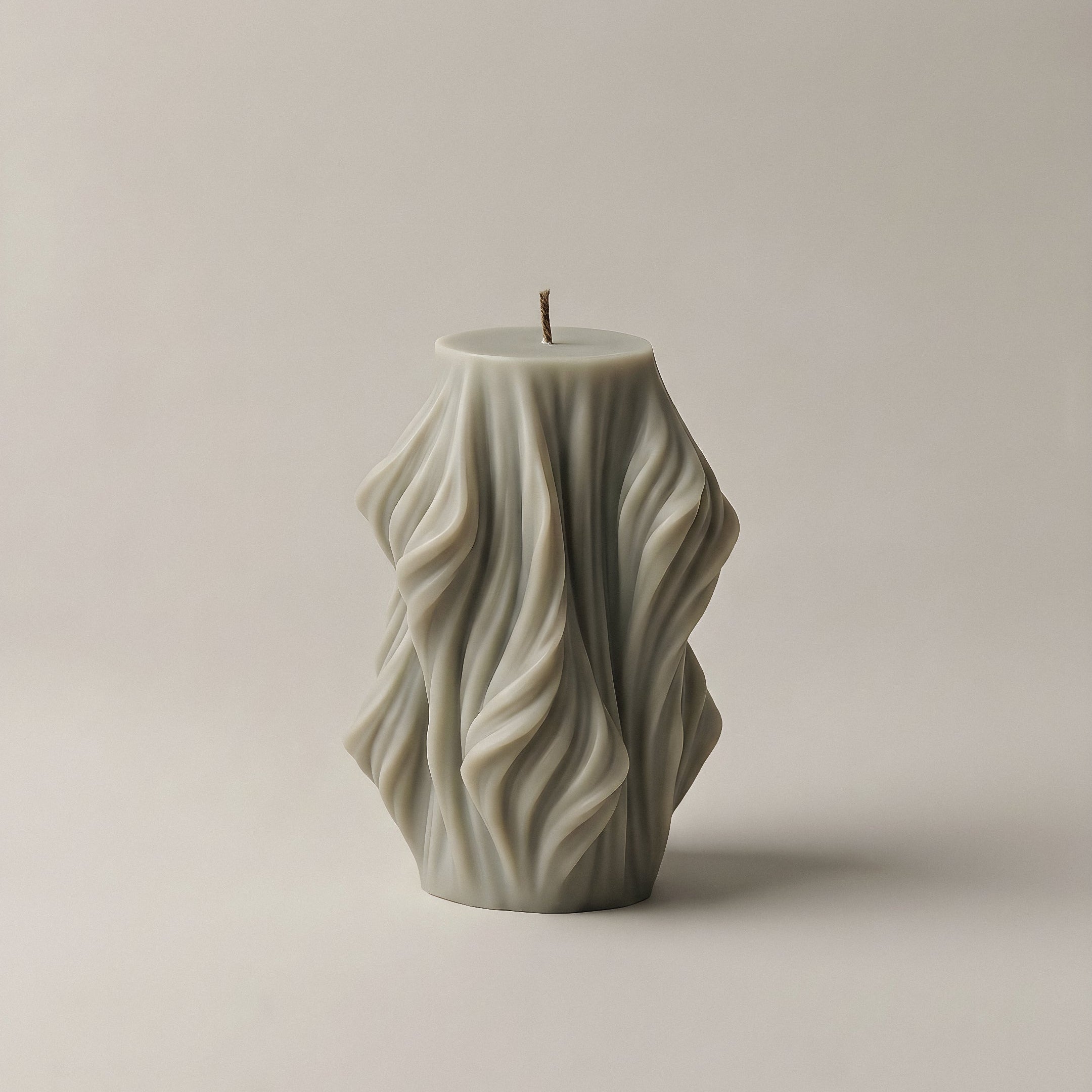 Close-up detail of handmade sculptural candle showing cascading wave texture in premium soy wax