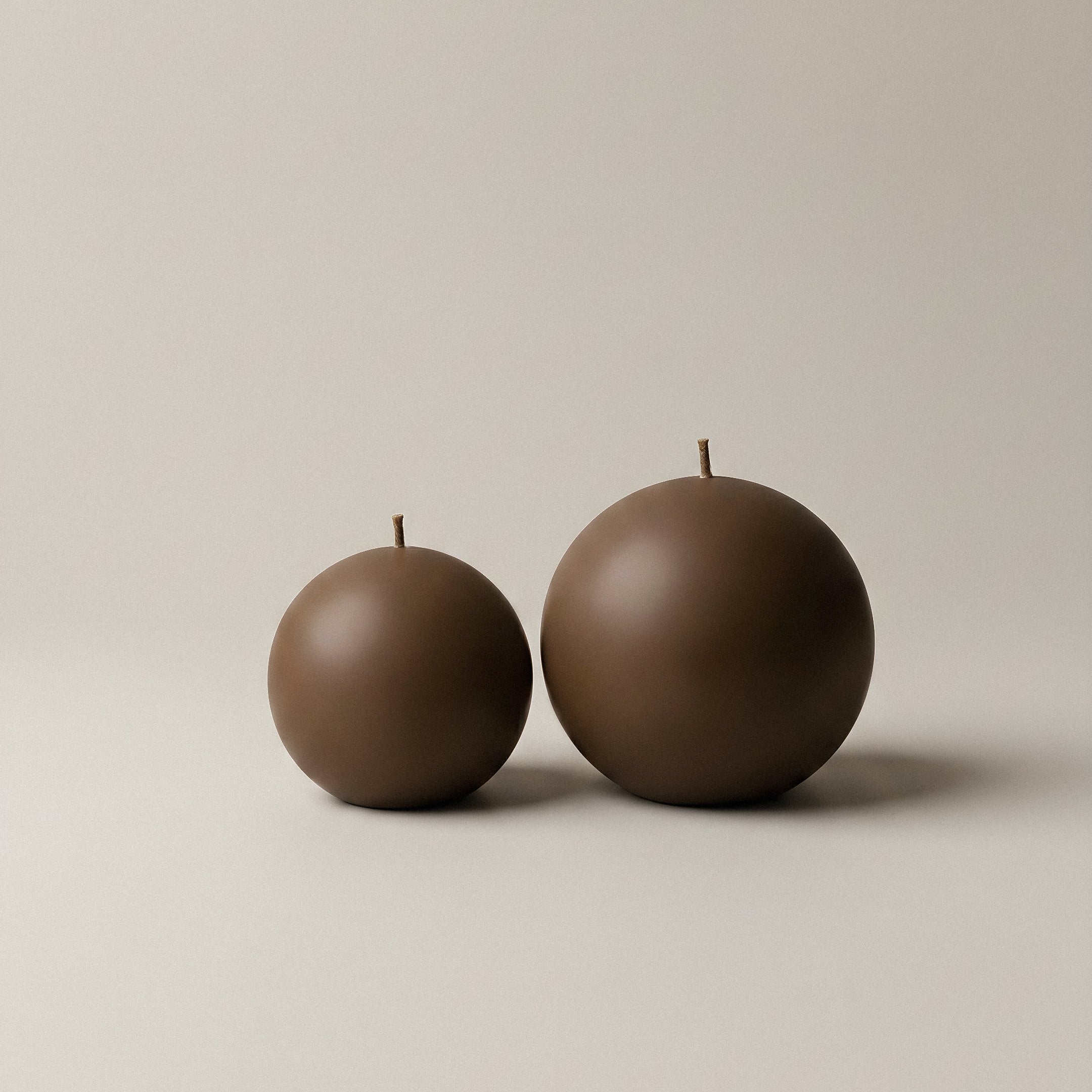 Close-up detail of handmade sphere candle showing smooth soy wax texture and cotton wick in minimalist setting