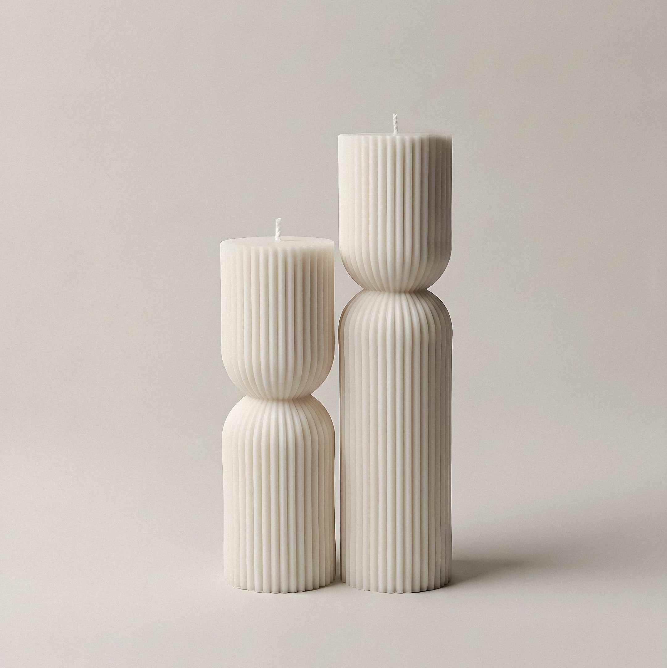 Close-up detail of handmade hourglass sculptural candle showing smooth soy wax texture and curves