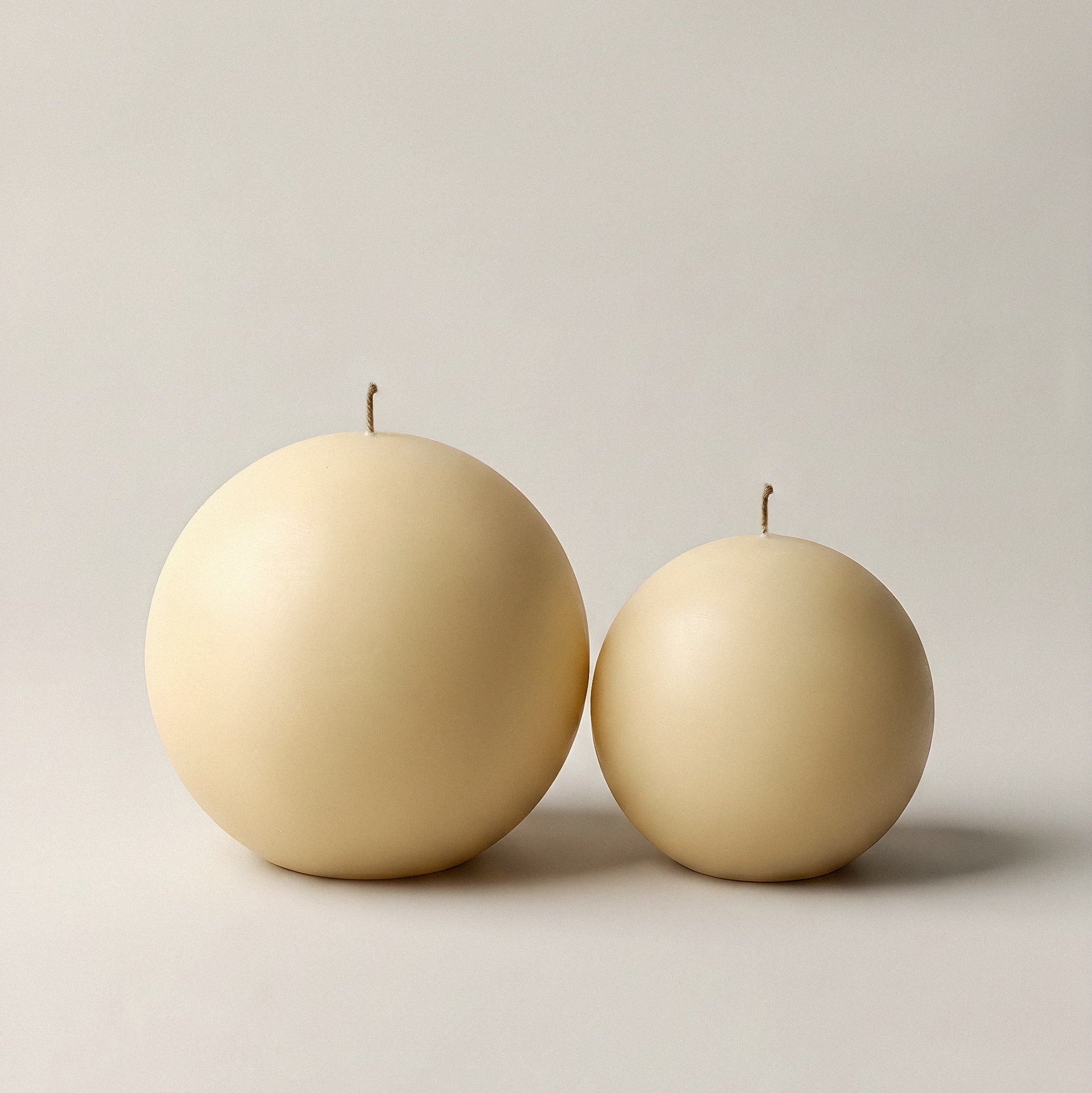 Handmade sculptural sphere candle detail showing smooth soy wax texture in minimalist Los Angeles studio setting