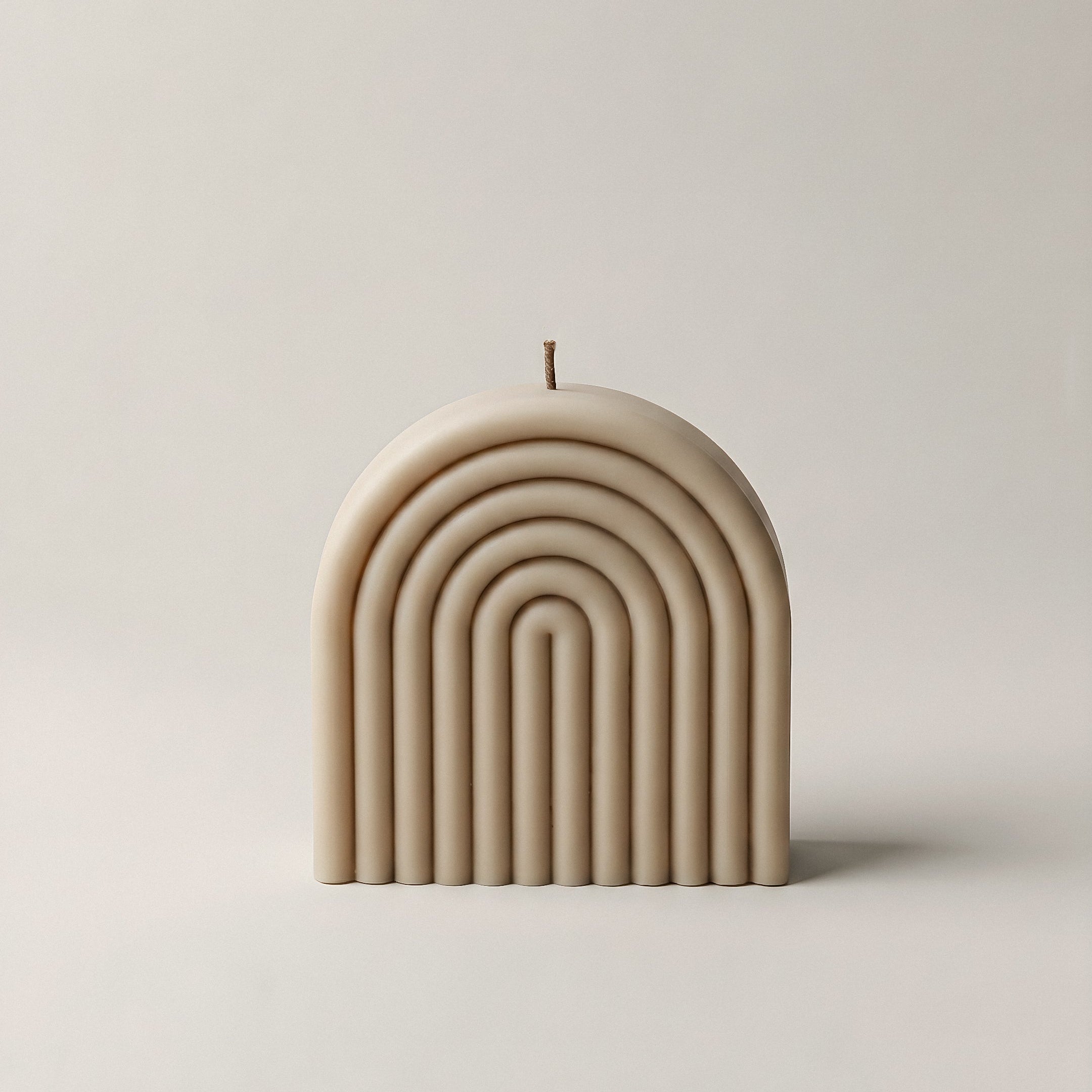 Rainbow sculptural candle detail showing handmade soy wax layers in vibrant colors on neutral background