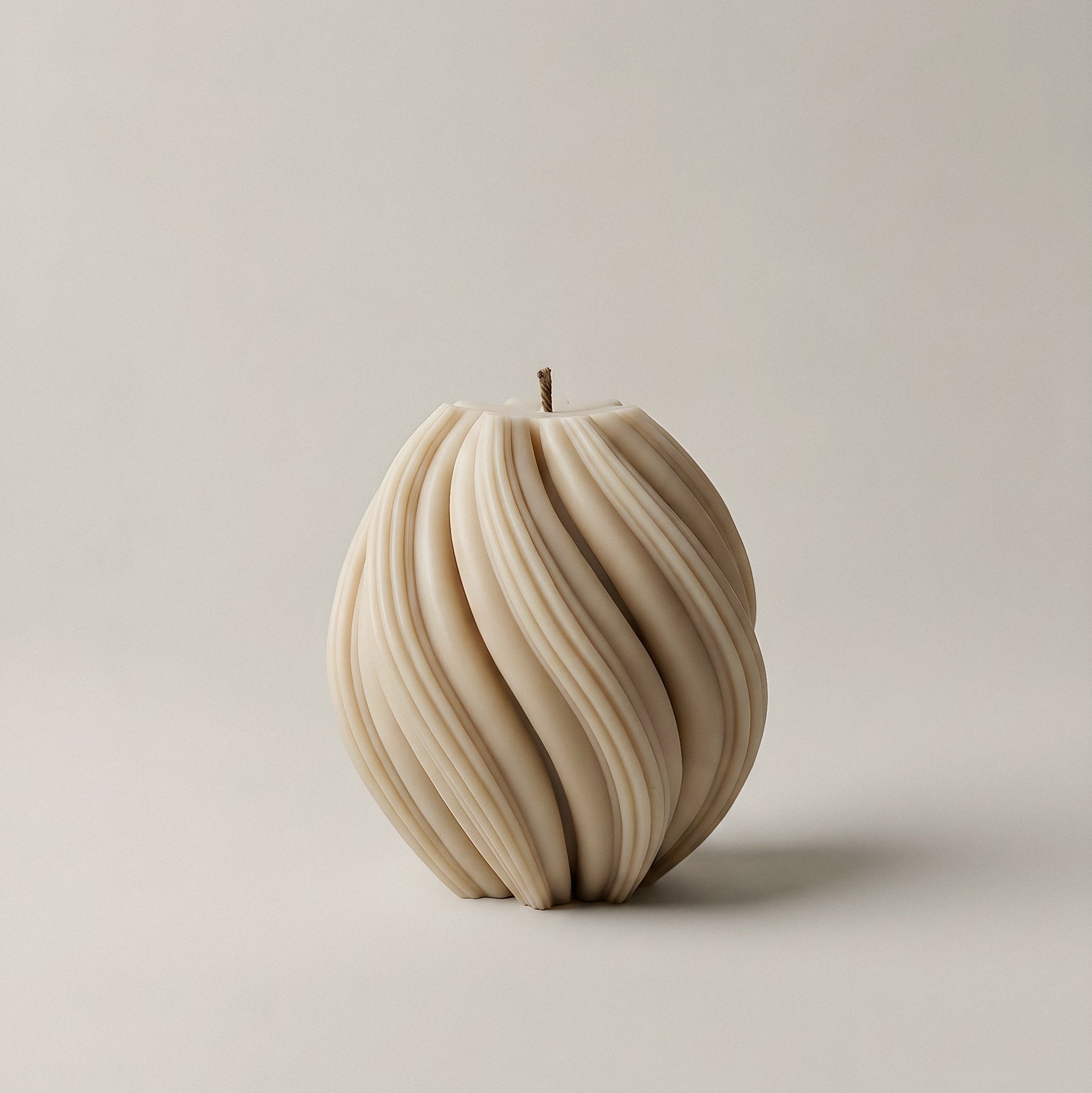 Close-up detail of handmade swirl sculptural candle showing textured ridges and premium soy wax finish
