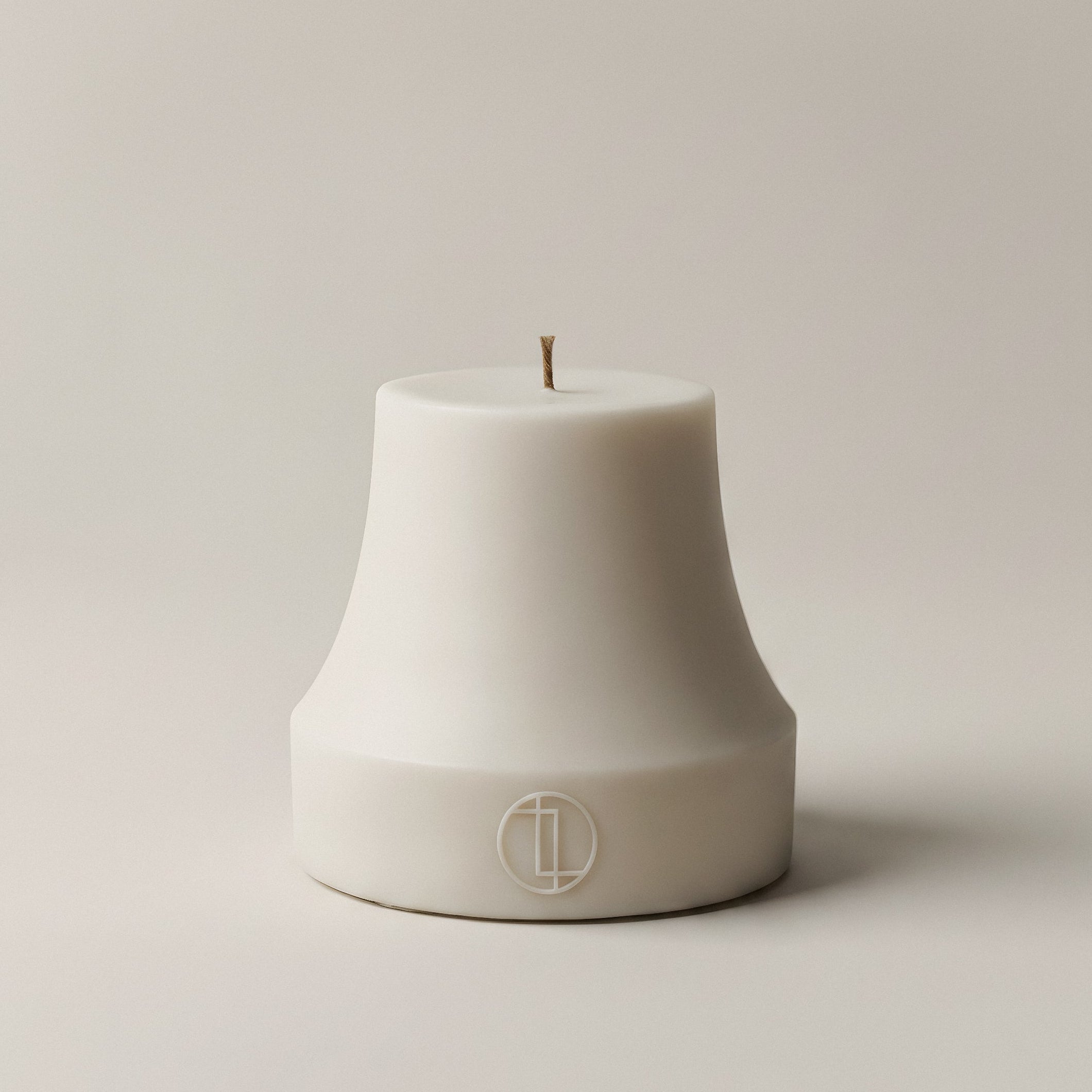 White bell-shaped sculptural candle handmade from premium soy wax against a neutral background