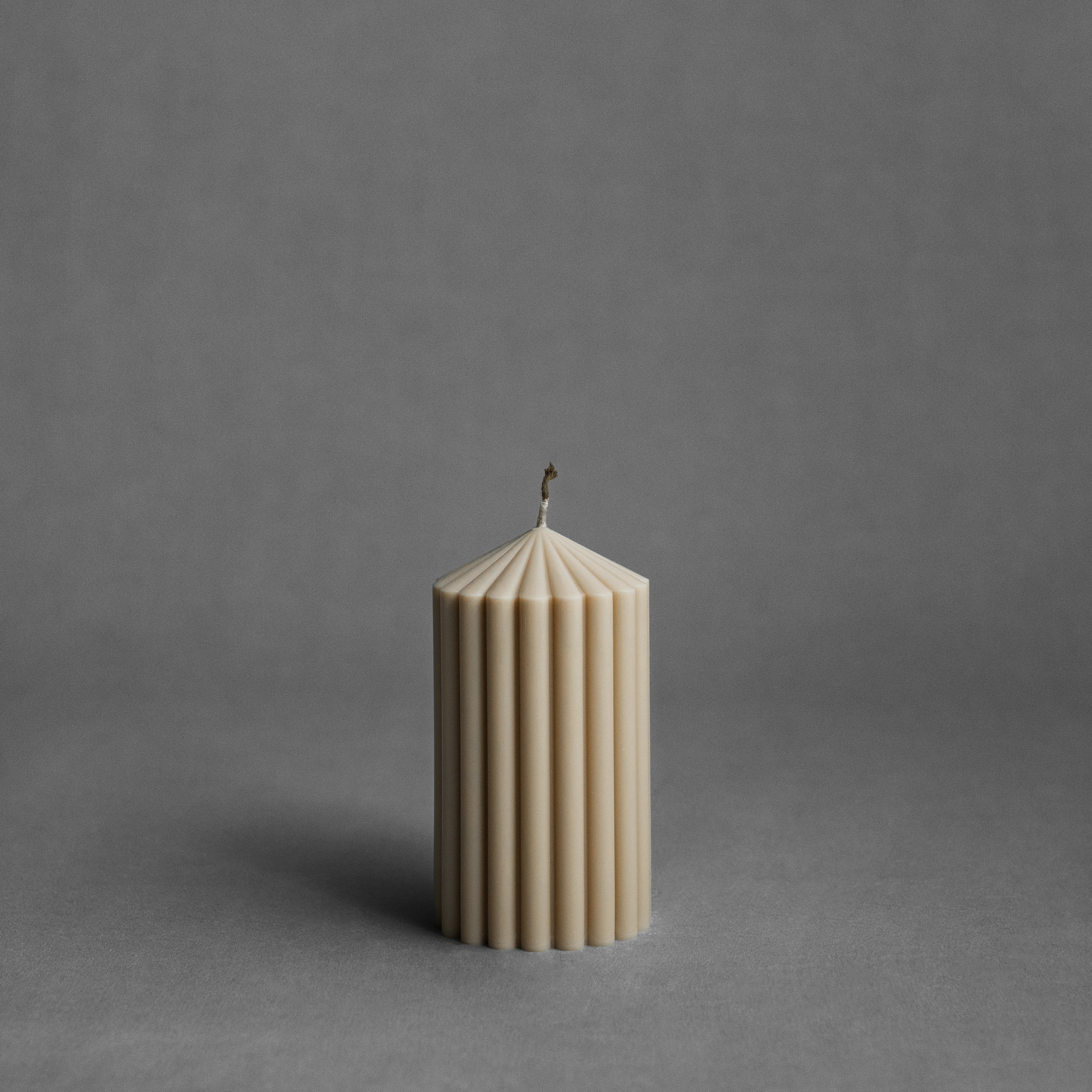Small sandstone peak pillar candle by LAWA with pointed sculptural top