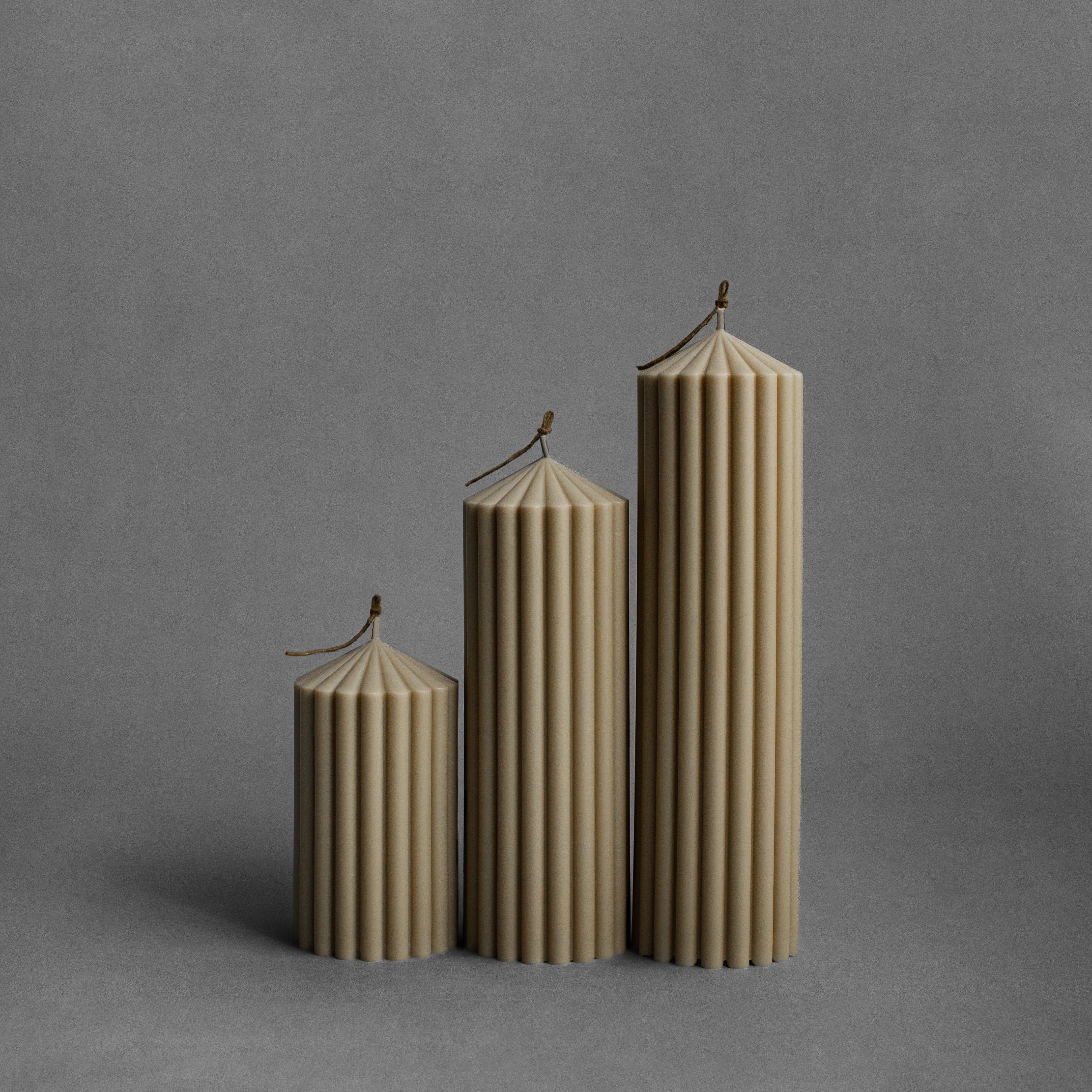 Set of three olive beige peak pillar candles by LAWA in small, medium, and large