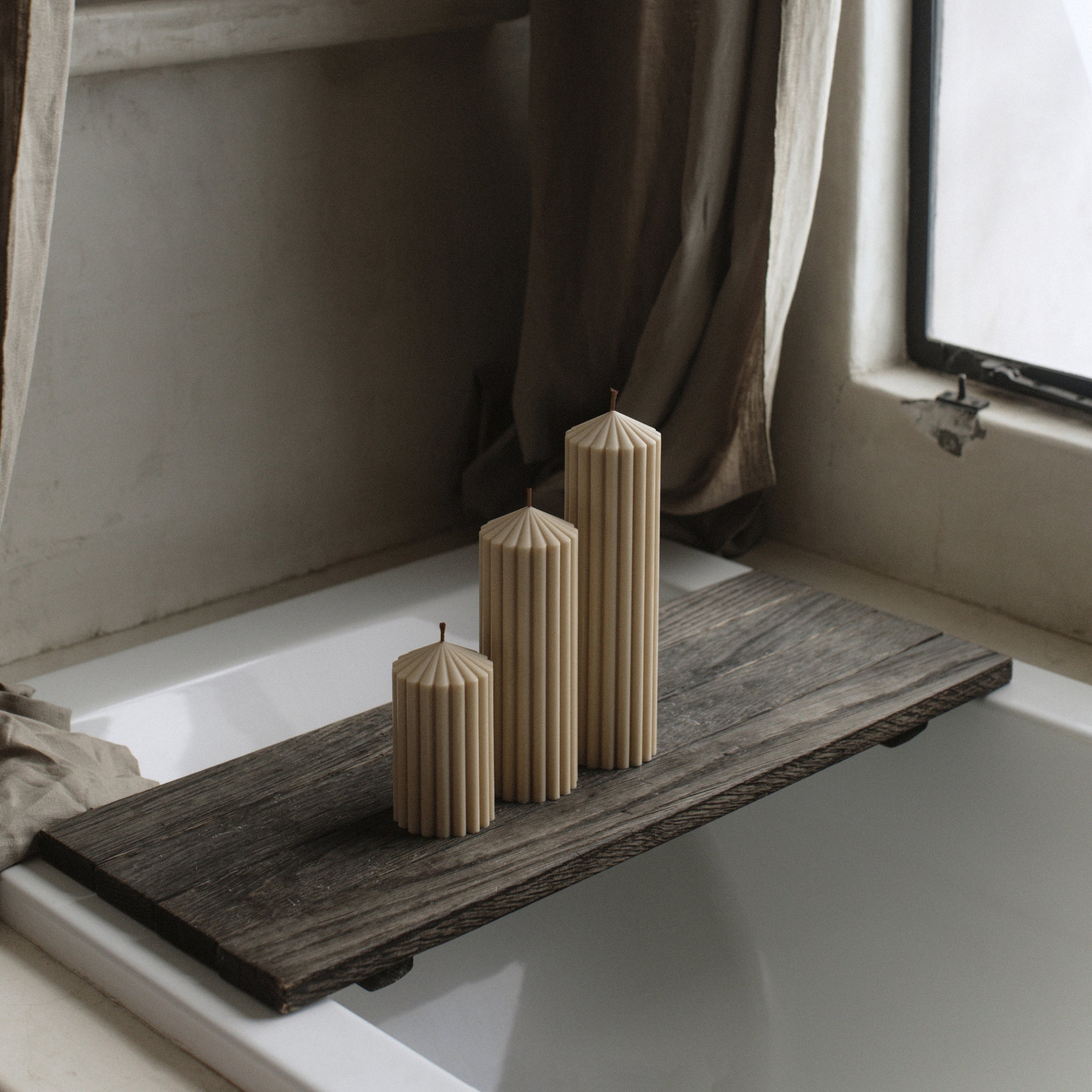 LAWA sandstone peak candle trio featuring warm minimalist mountain-inspired forms on a wooden tray by a window with curtains.