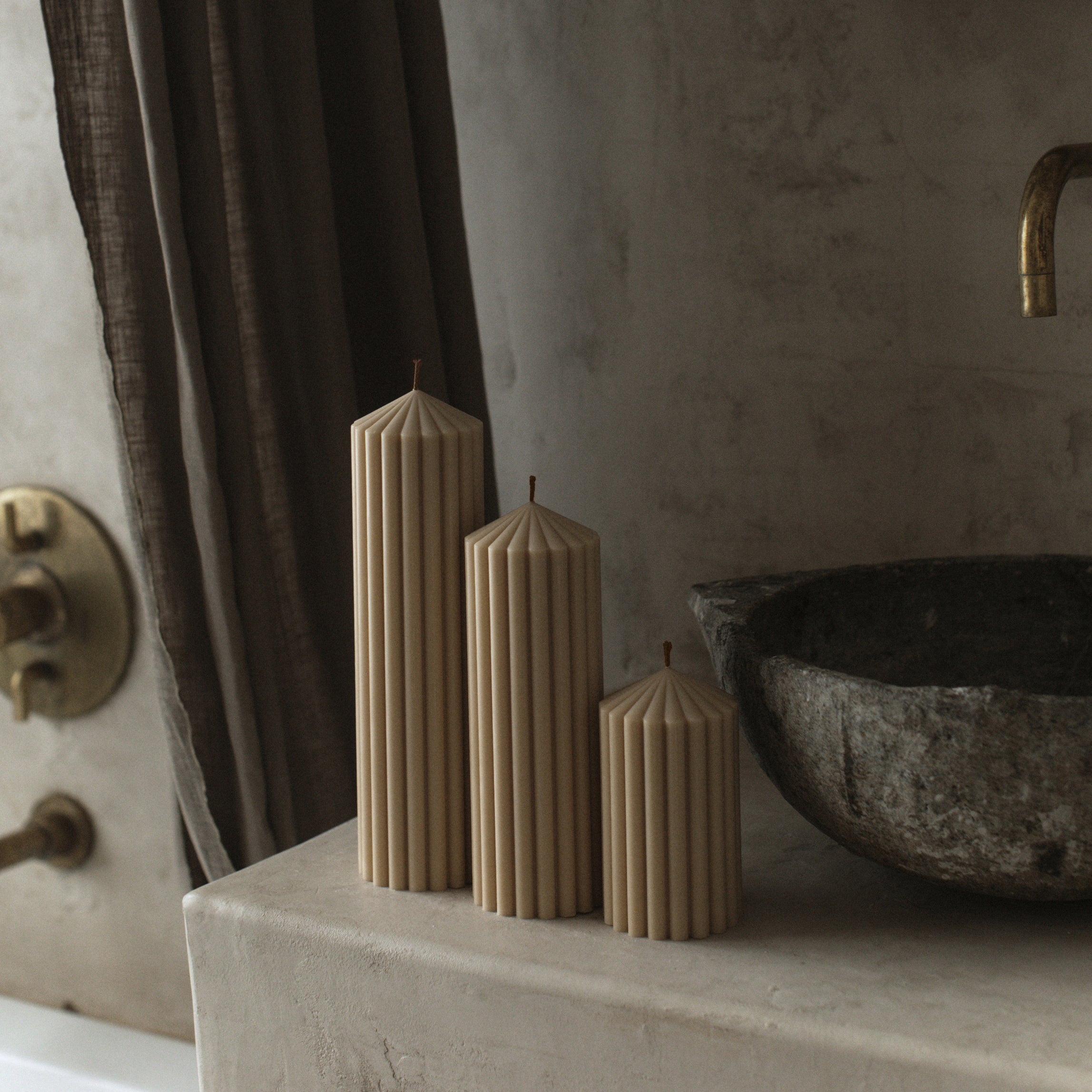 Sandstone soy wax peak pillar candle set of 3 by LAWA with modern geometric silhouettes on a stone surface with a rustic background