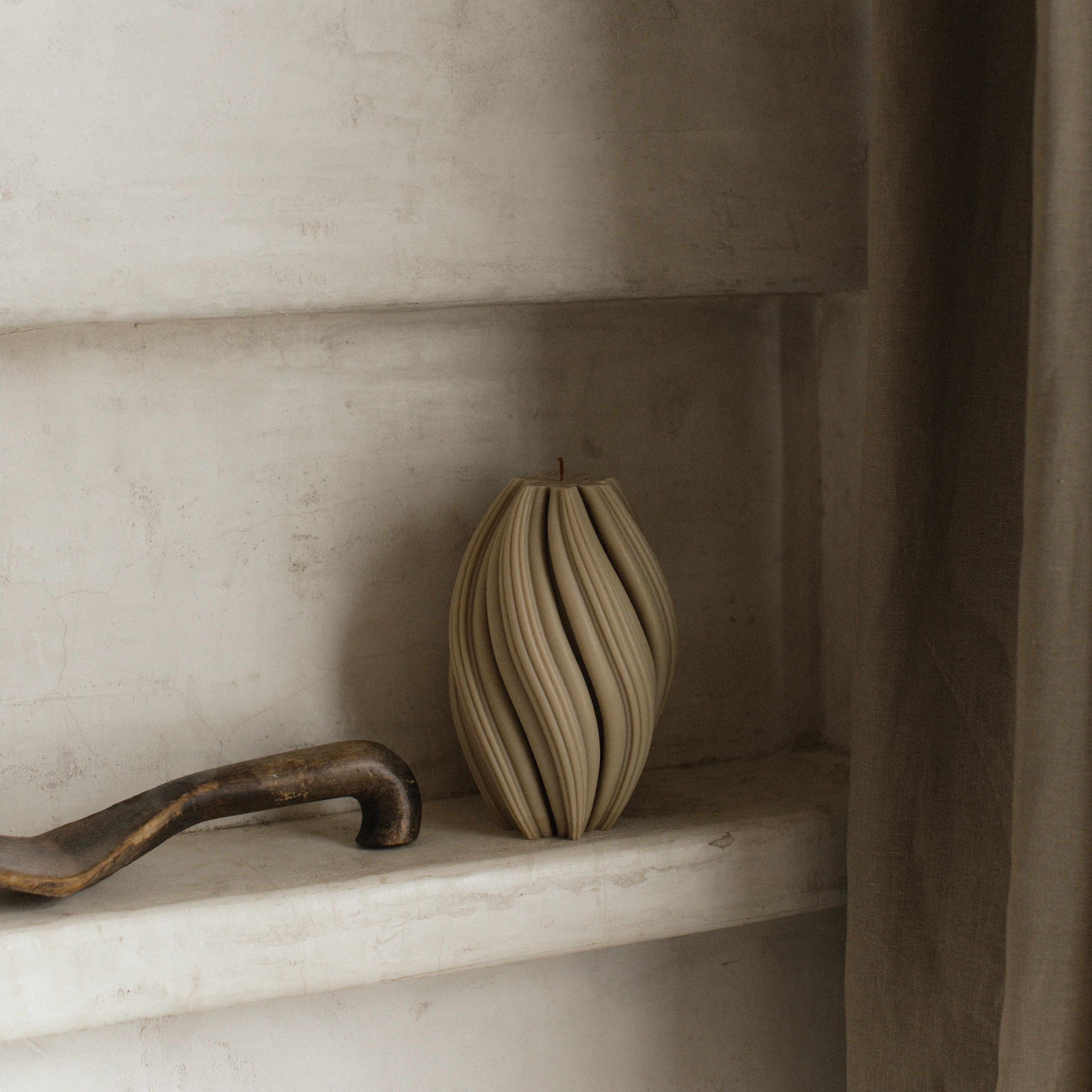 LAWA large olive beige swirl candle featuring a tall twisted textured design on a marble shelf with a rustic handle.