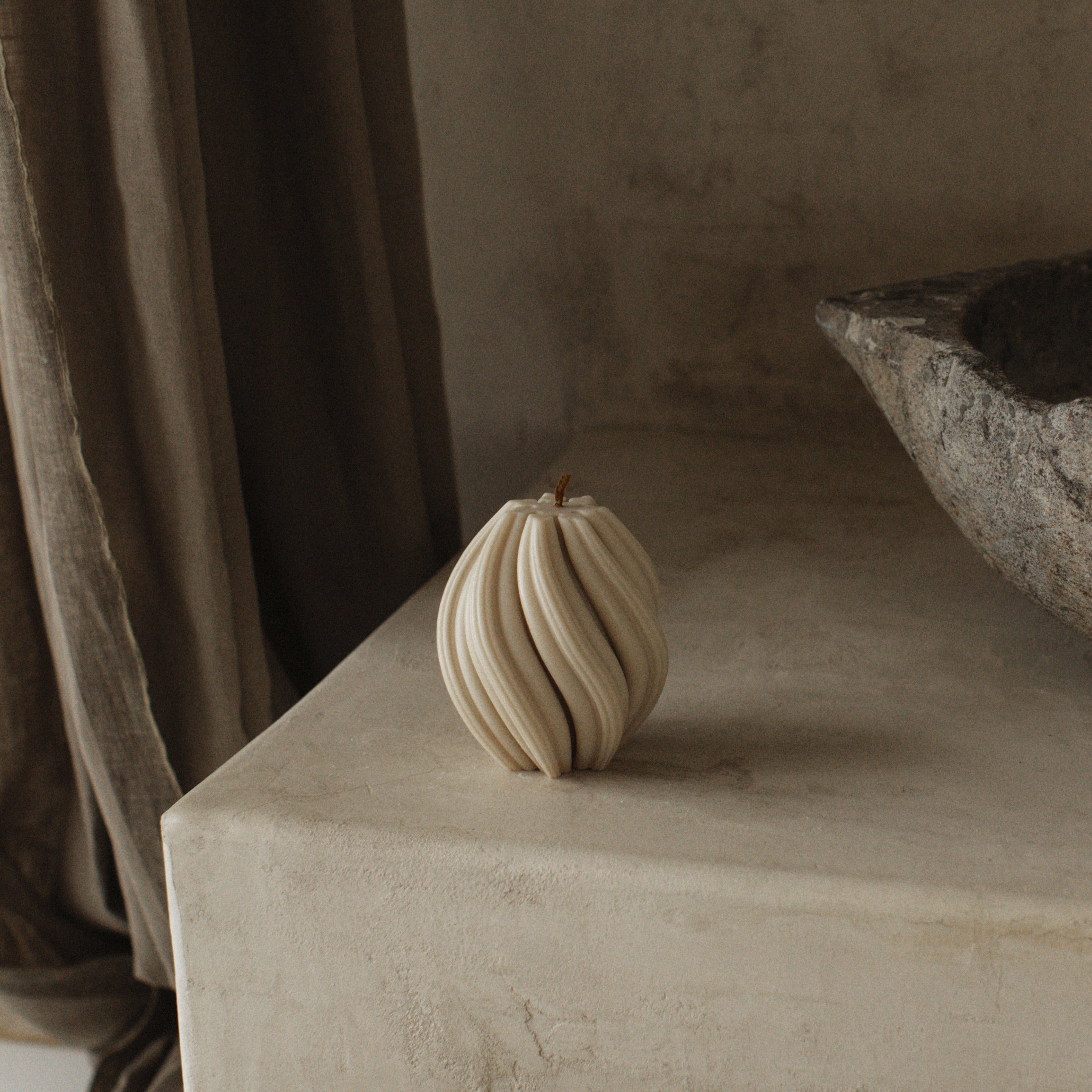 LAWA small moon gray swirl candle featuring sculptural spiral texture on a textured surface with a neutral background