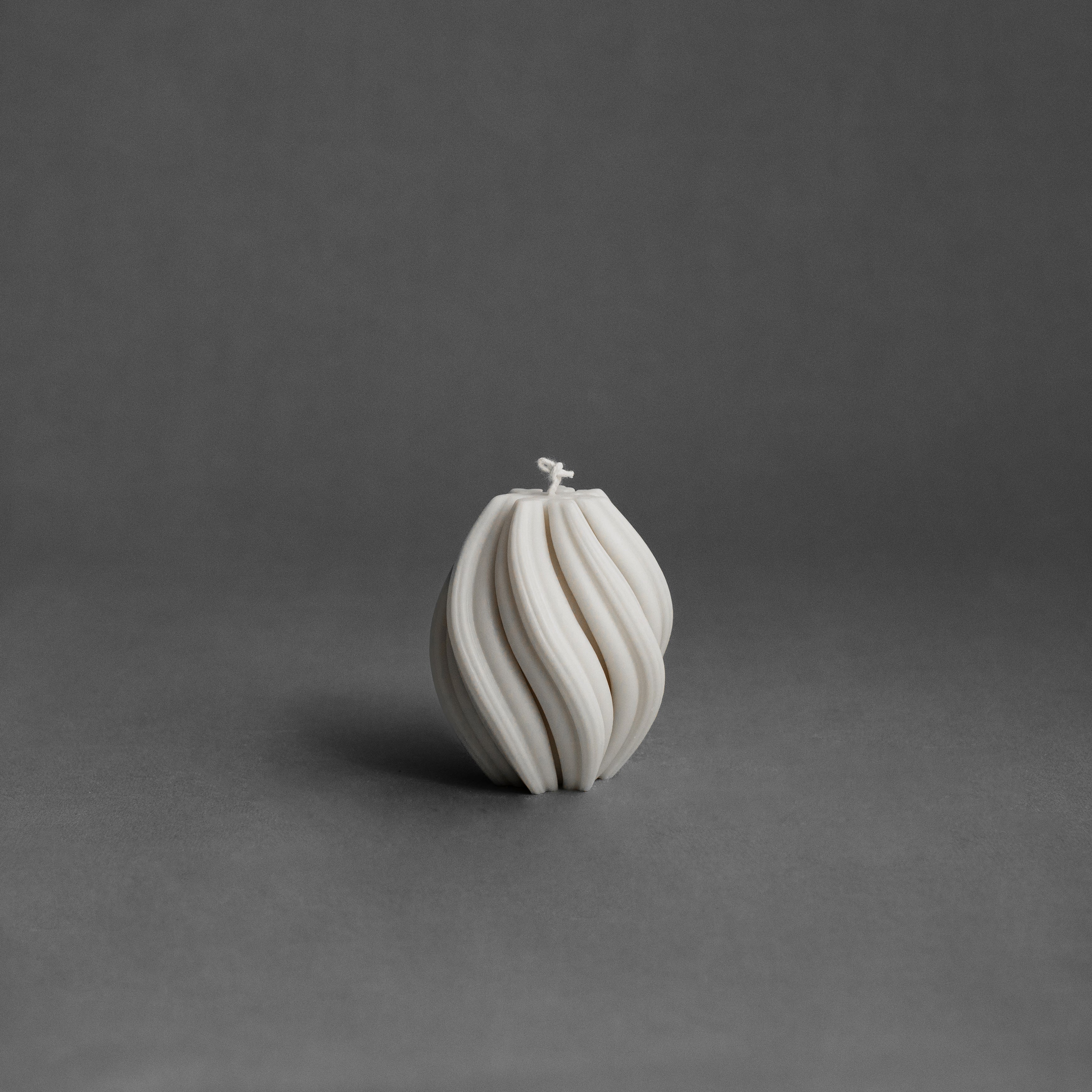 Small white swirl pillar candle by LAWA with soft spiral sculptural detailing