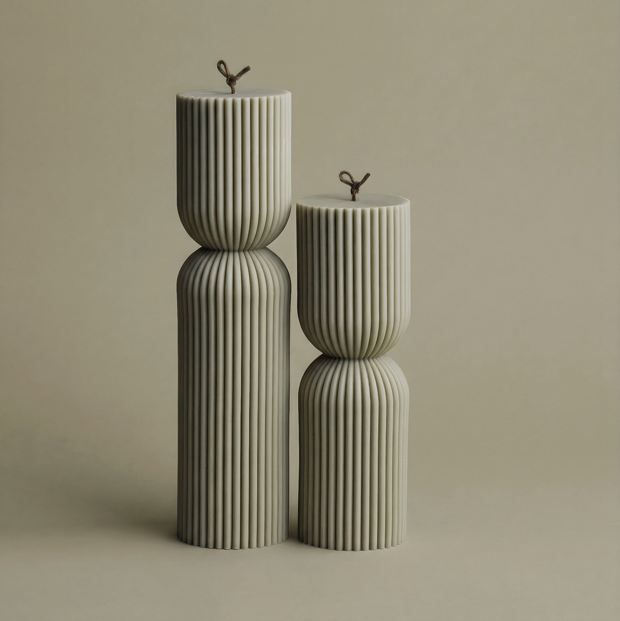 Close-up detail of handmade hourglass sculptural candle showing smooth soy wax texture and cotton wick
