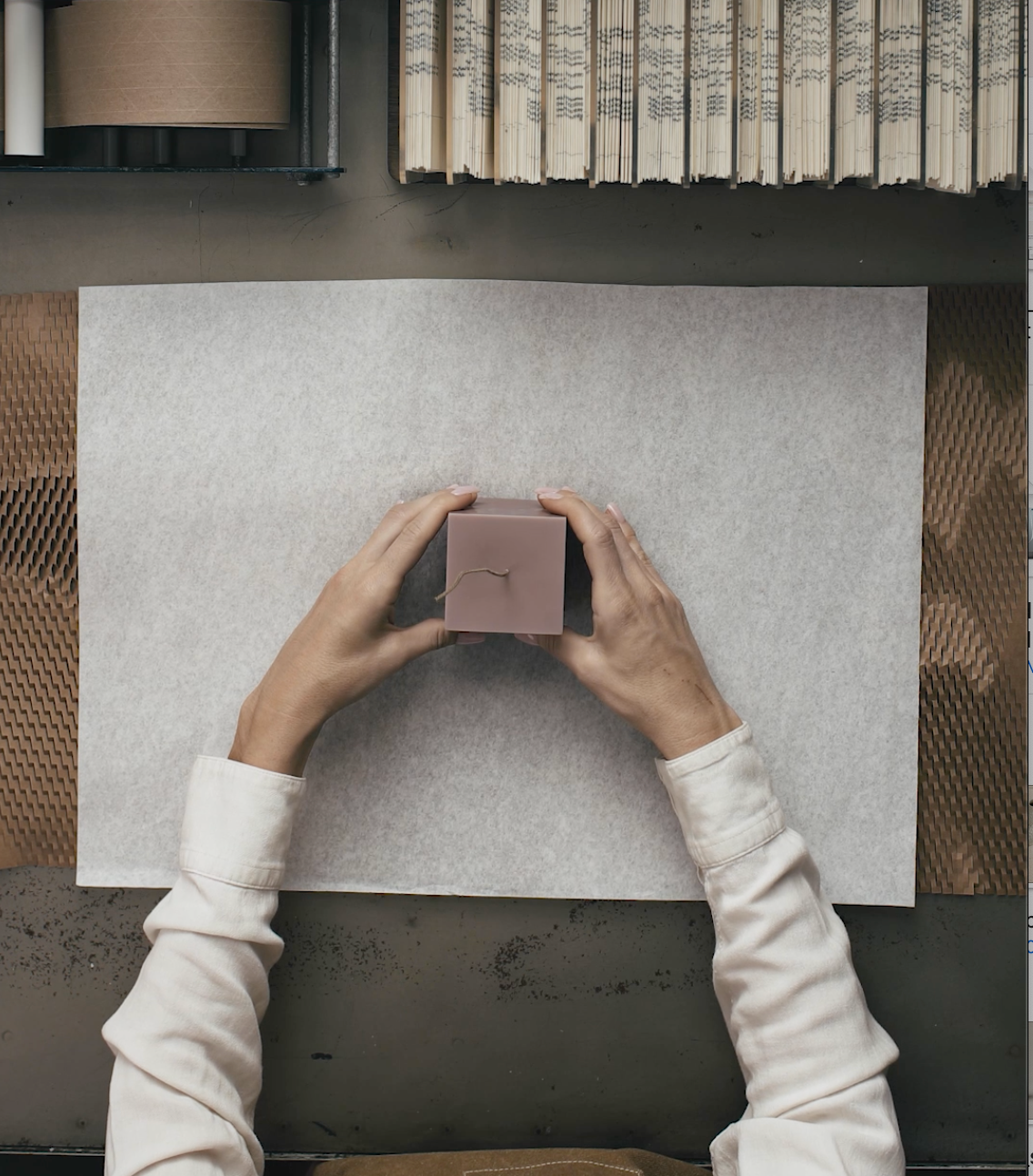 Hands opening LAWA Candles biodegradable packaging — plastic-free candle box handmade in Los Angeles