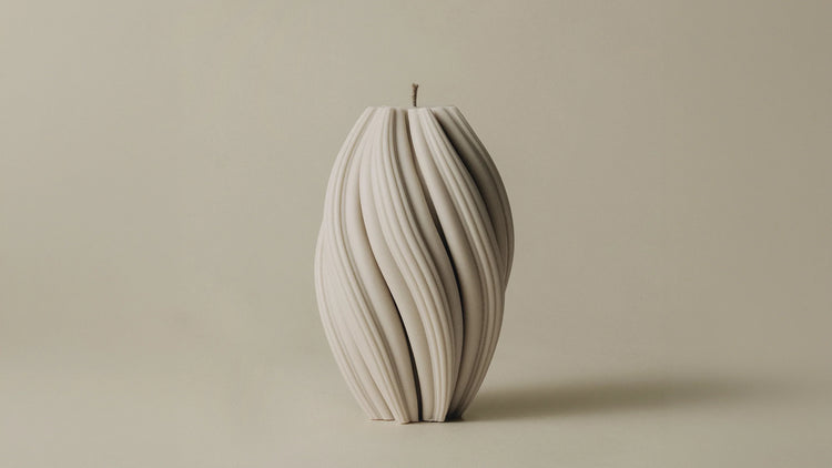 A large swirl candle with continuous twisting ridges in sandstone, shown against a neutral background.