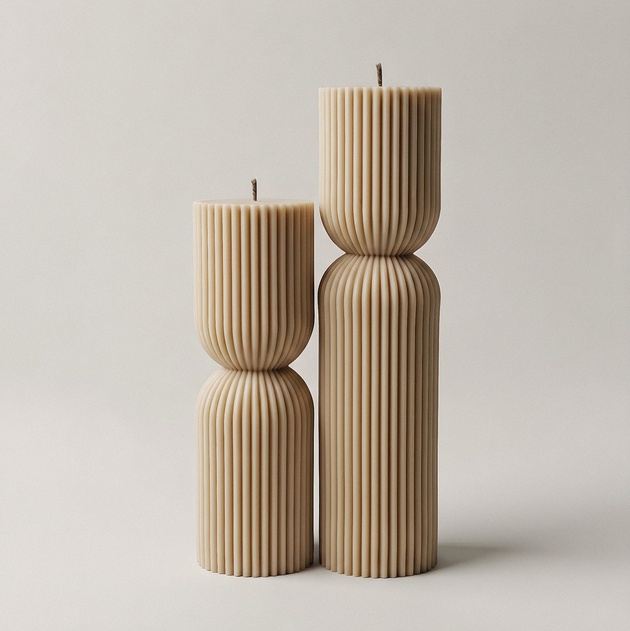 Close-up detail of handmade hourglass sculptural candle showing smooth soy wax texture and curved silhouette