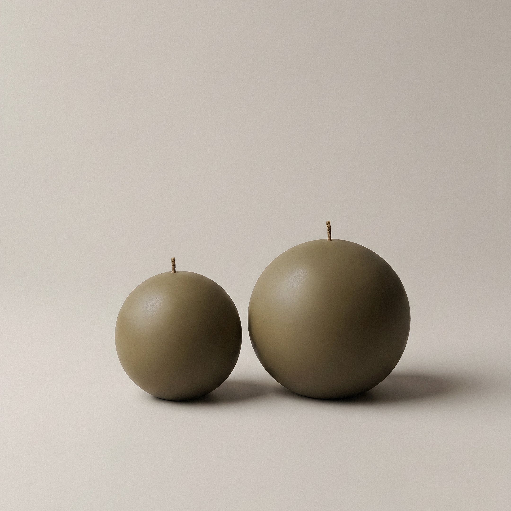 Close-up detail of handmade sphere candle showing smooth soy wax texture and sculptural rounded form
