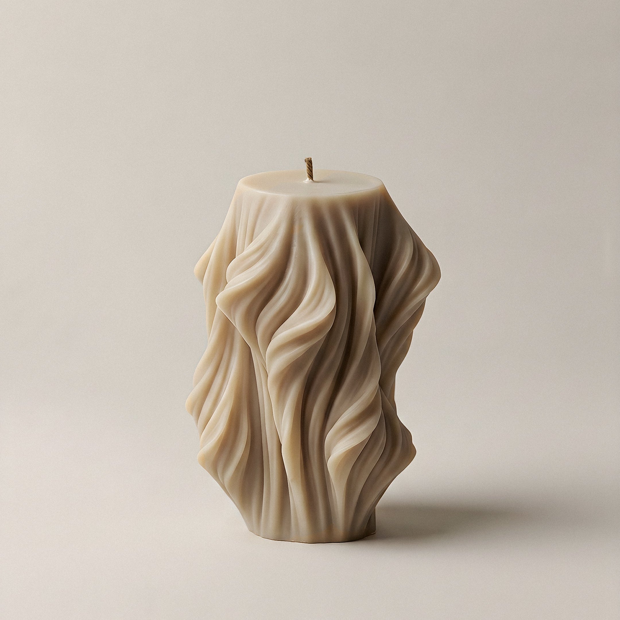 Close-up detail of handmade sculptural candle showcasing cascading wave texture in premium soy wax