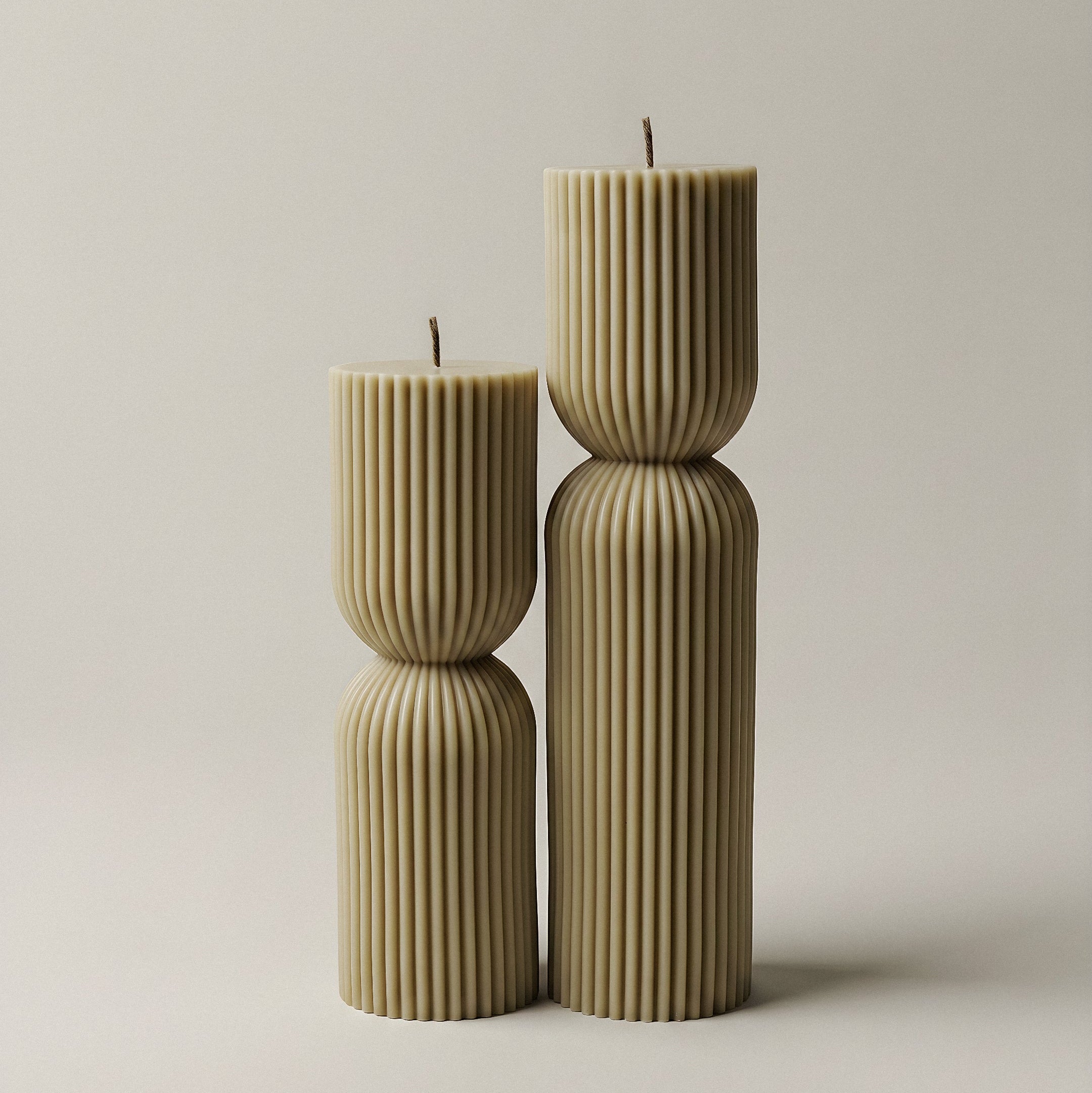 Close-up detail of handmade hourglass sculptural candle showing smooth soy wax texture and cotton wick