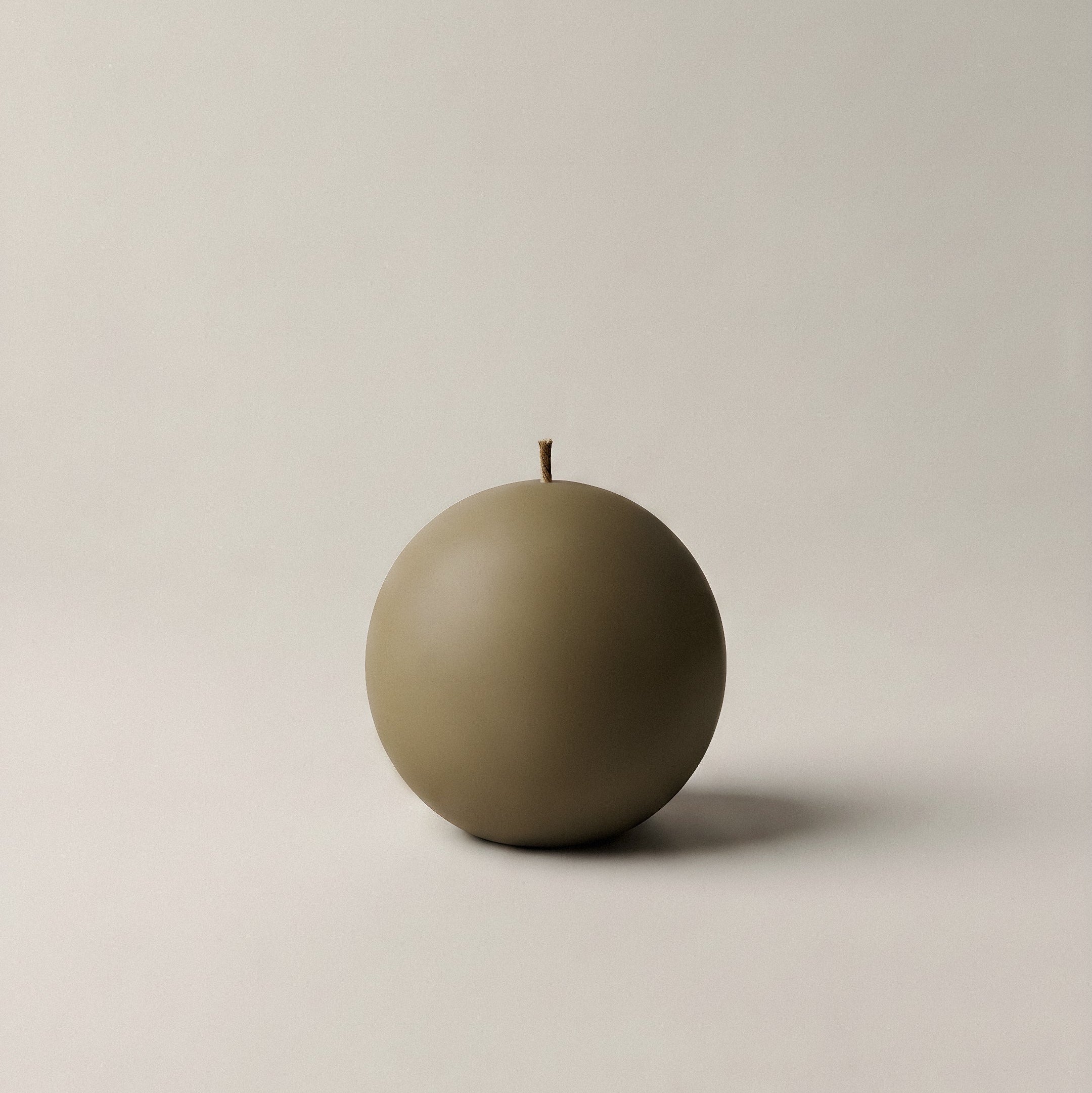 Handmade sphere sculptural candle detail showing smooth soy wax texture in minimalist Los Angeles studio setting