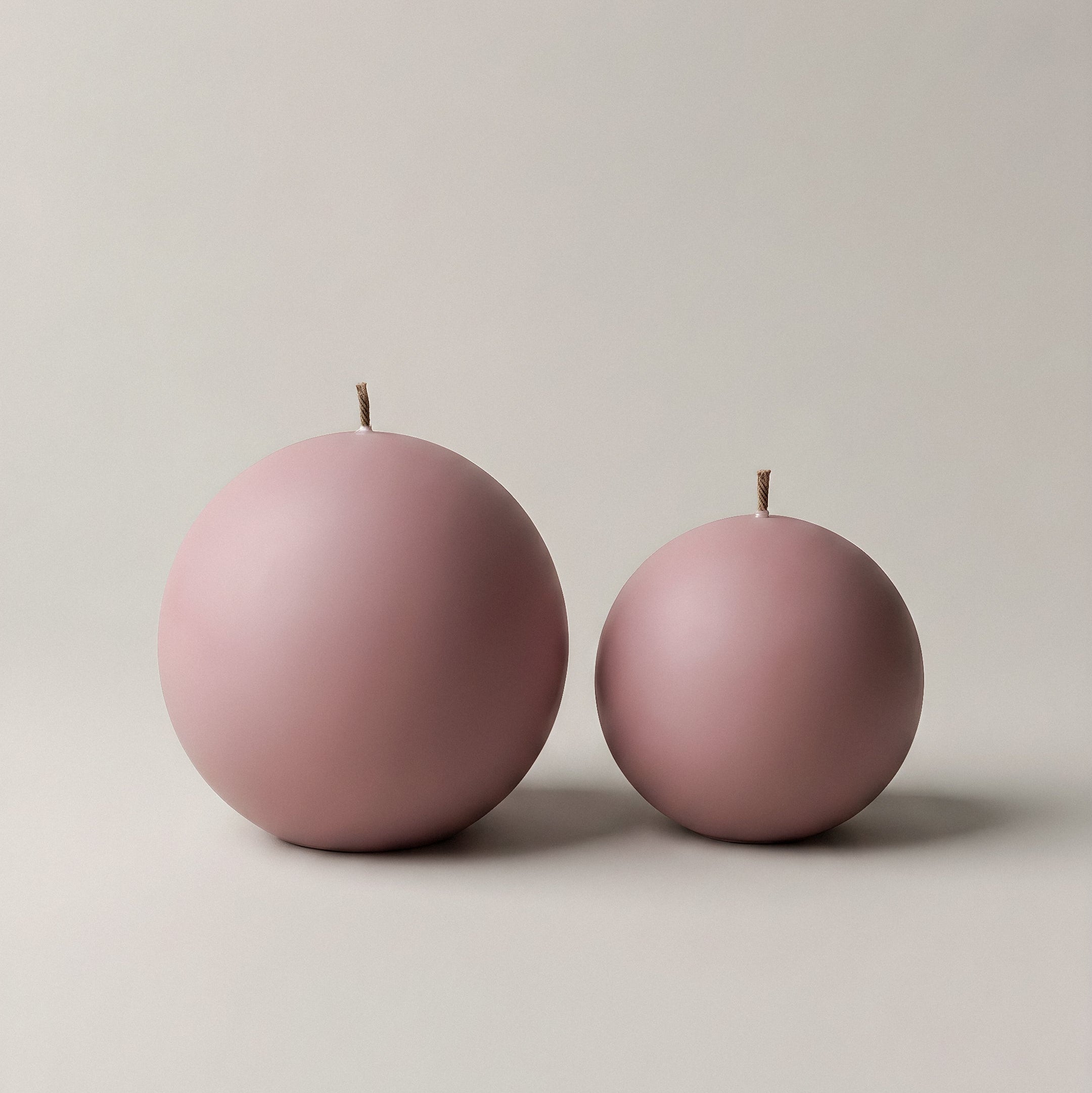Handmade sphere sculptural candle in soy wax on minimalist table setting with natural light and shadows