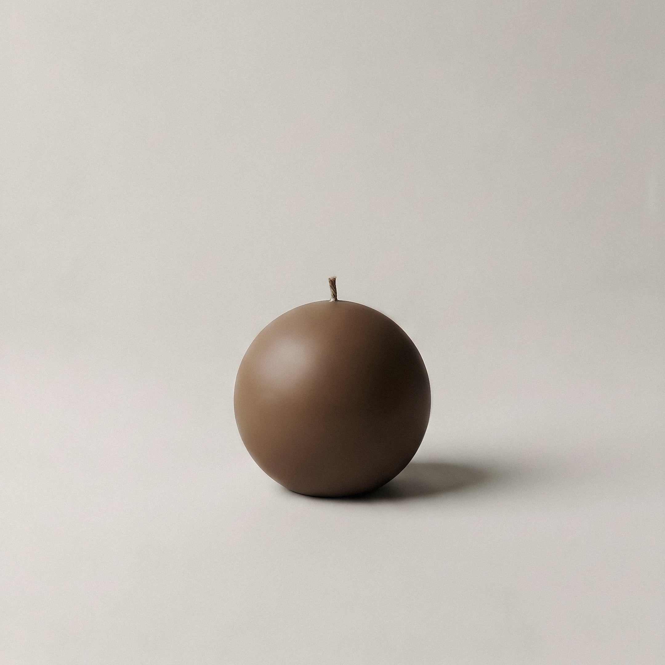 Handmade sphere candle detail showing smooth soy wax texture and natural cotton wick in minimalist setting
