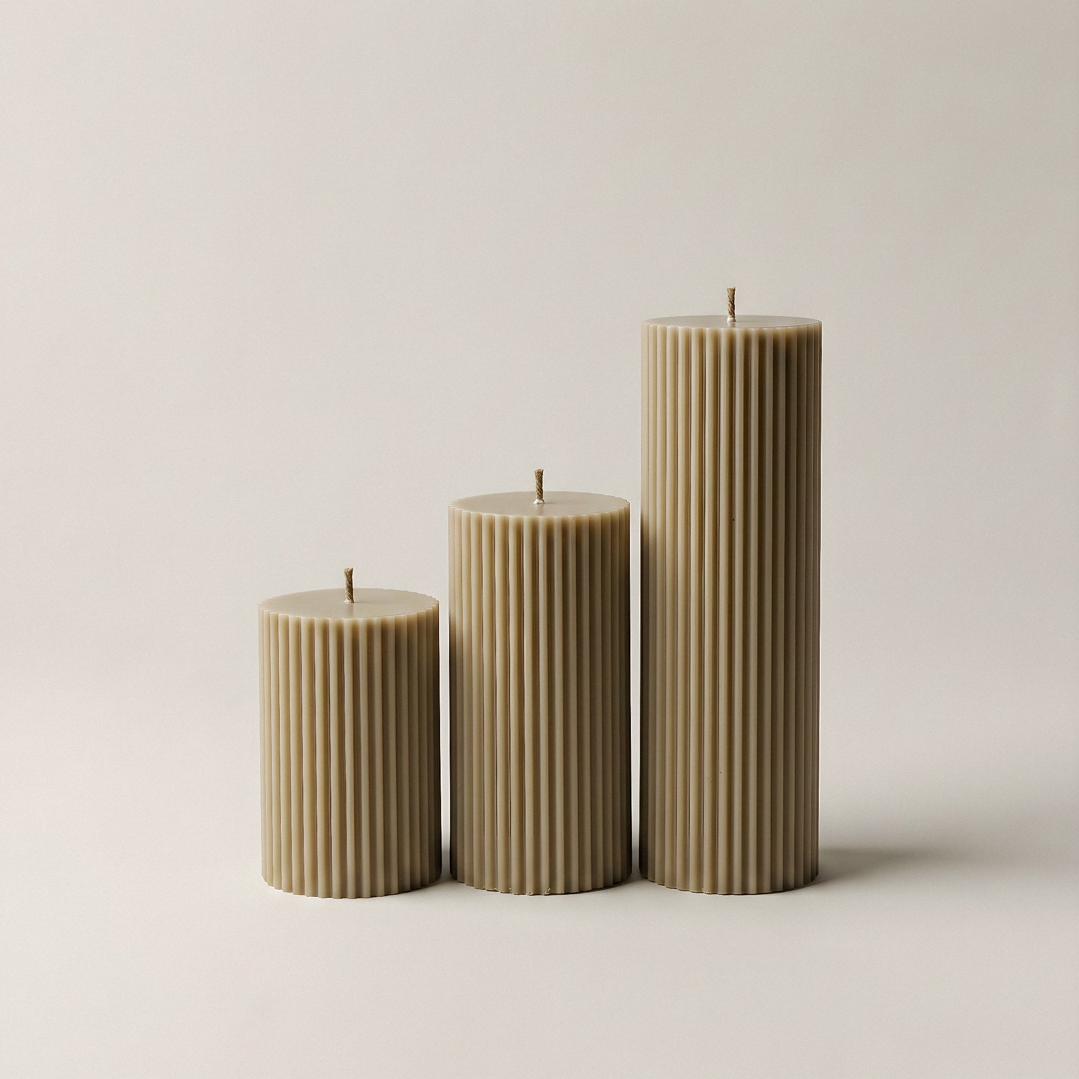 Close-up detail of handmade ribbed sculptural candle showing textured soy wax surface and natural cotton wick