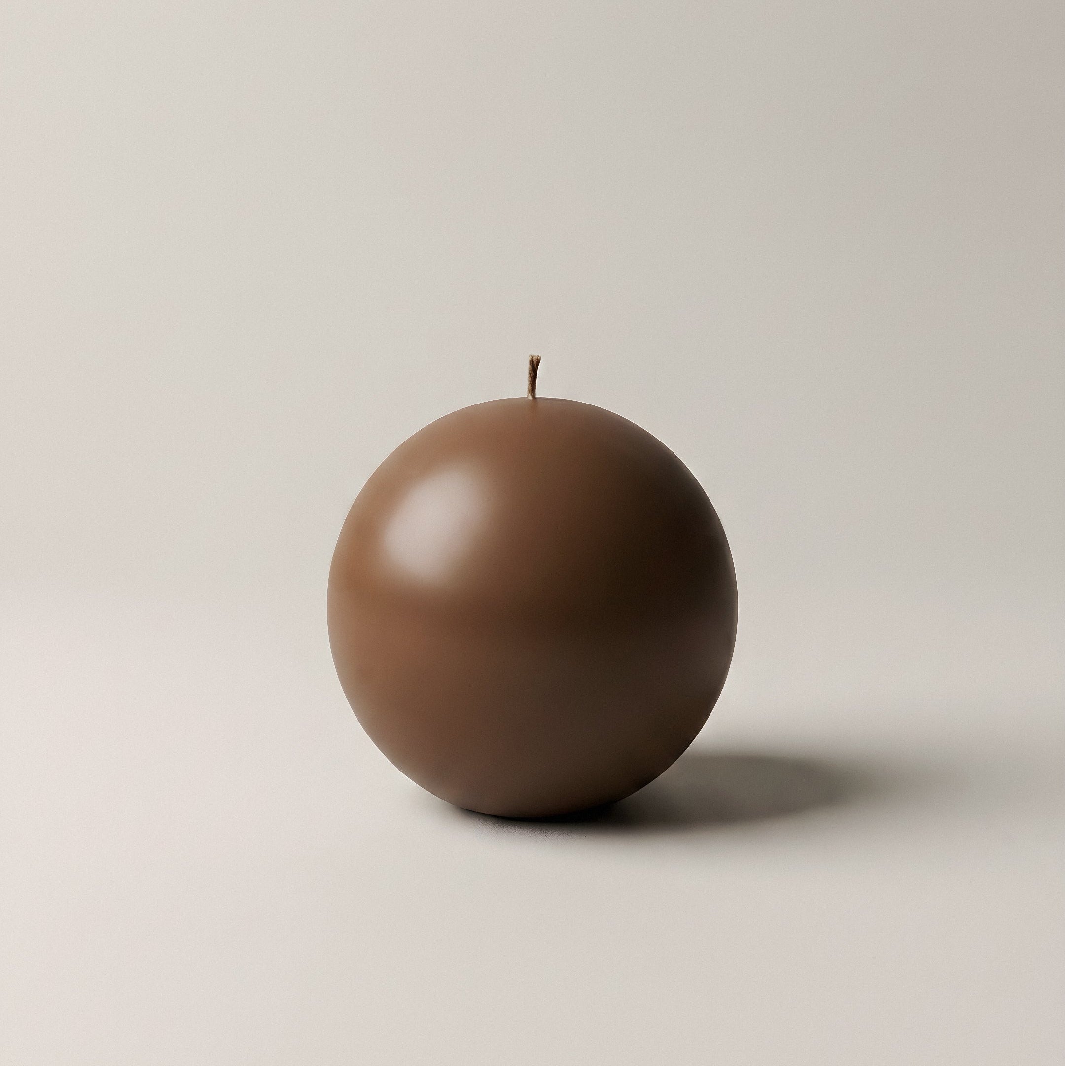 Close-up detail of handmade sculptural candle showing organic texture of premium soy wax in imperfect sphere shape