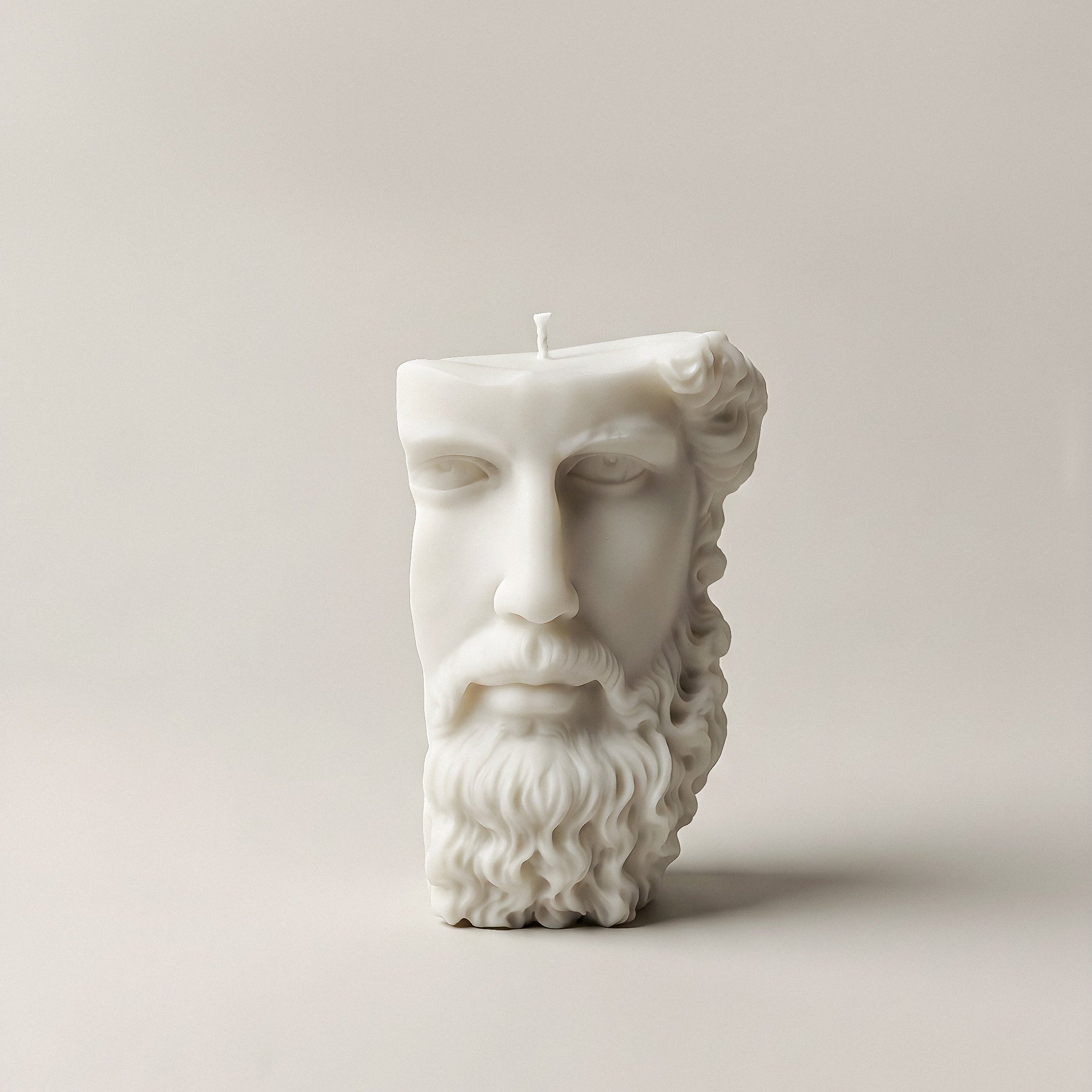 Close-up detail of handmade Greek face sculptural candle showing textured soy wax surface and cotton wick