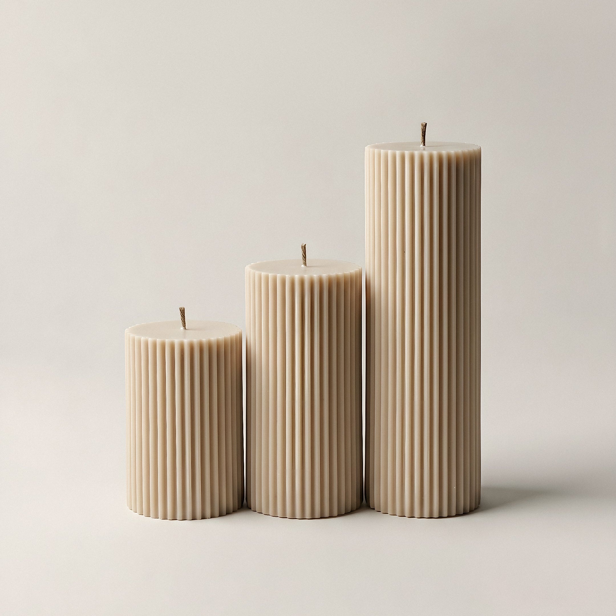 Close-up detail of handmade ribbed sculptural candle showing textured soy wax surface and natural cotton wick
