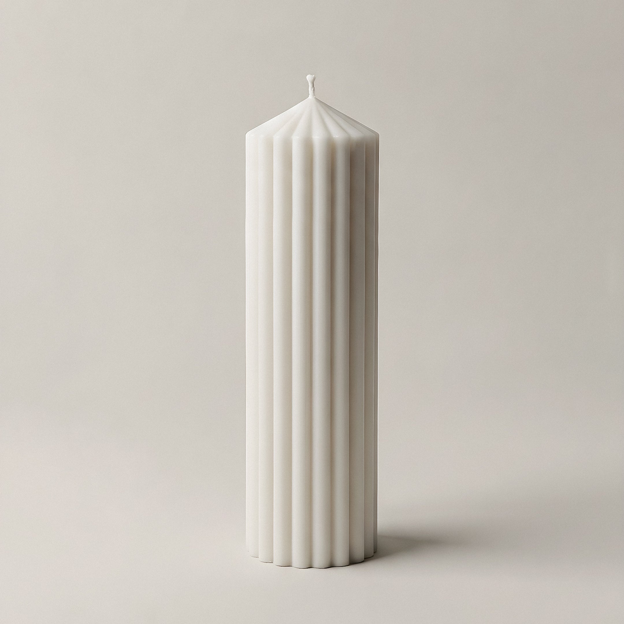 Peak sculptural candle in white soy wax displayed on natural surface with soft lighting detail shot