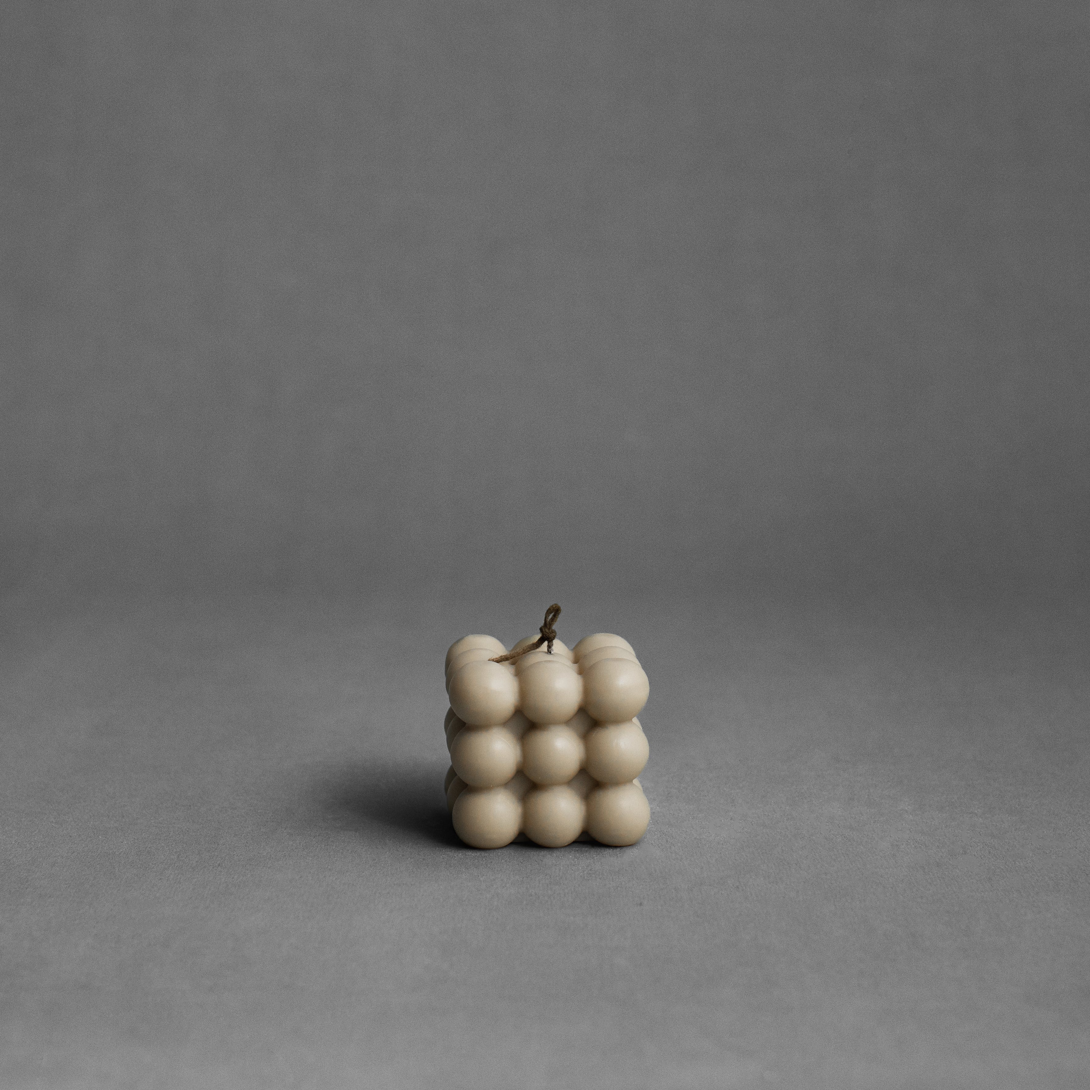 Sandstone bubble pillar candle by LAWA with warm-toned sculptural bubble design