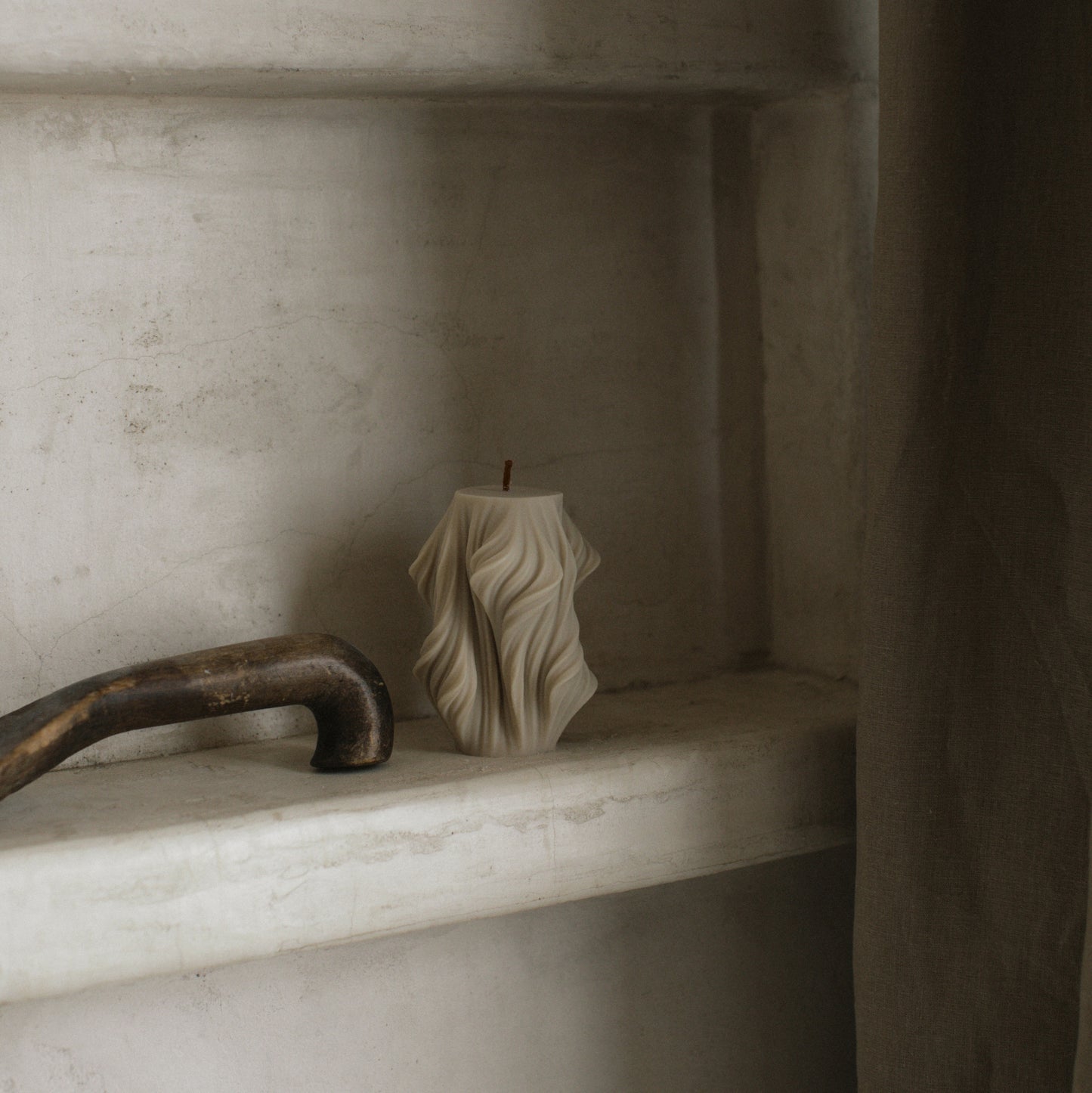 Close-up detail of handmade sculptural candle showing cascading wave texture in premium soy wax