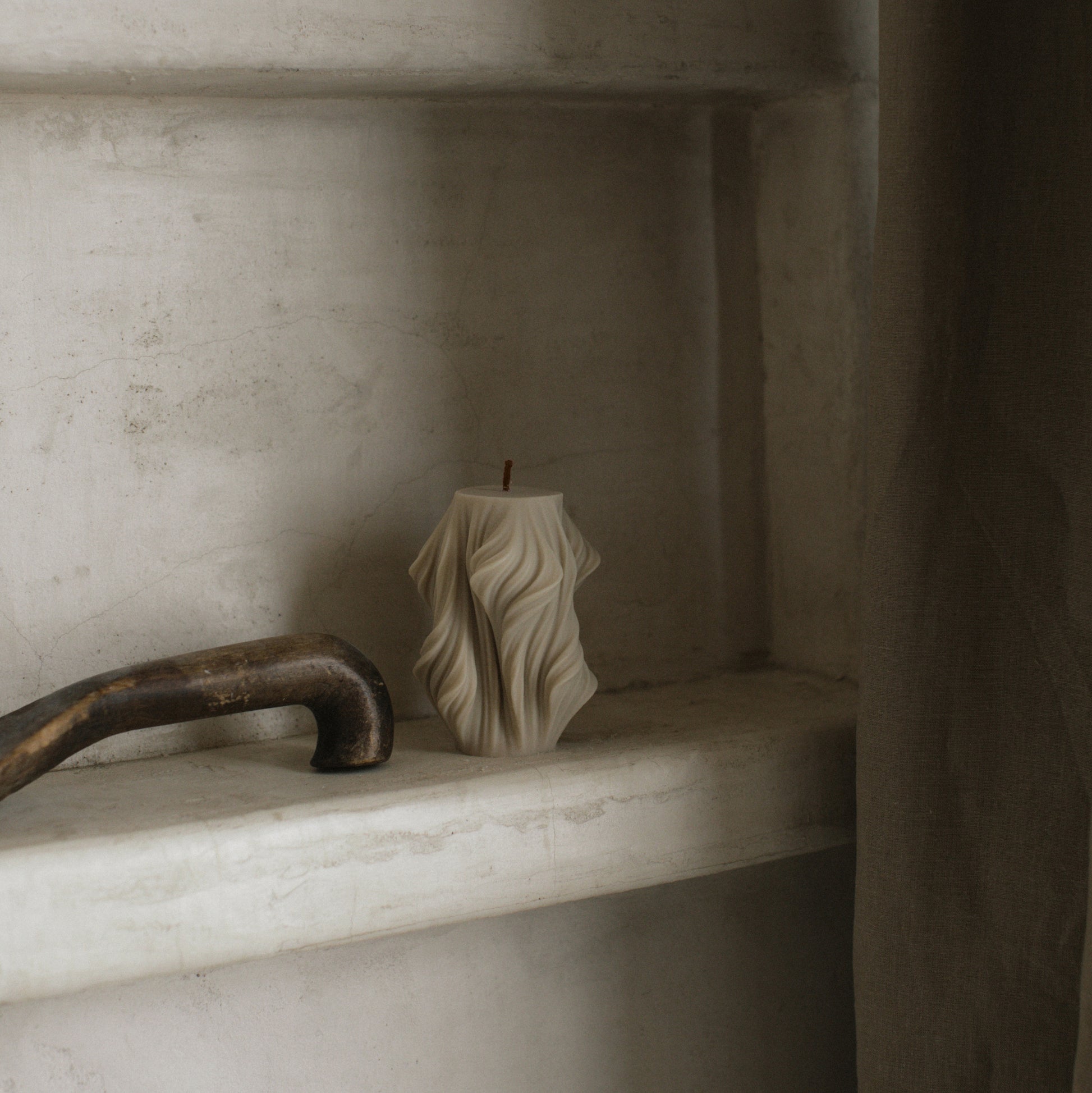 Close-up detail of handmade sculptural candle showing cascading wave texture in premium soy wax