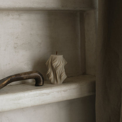 Close-up detail of handmade sculptural candle showing cascading wave texture in premium soy wax
