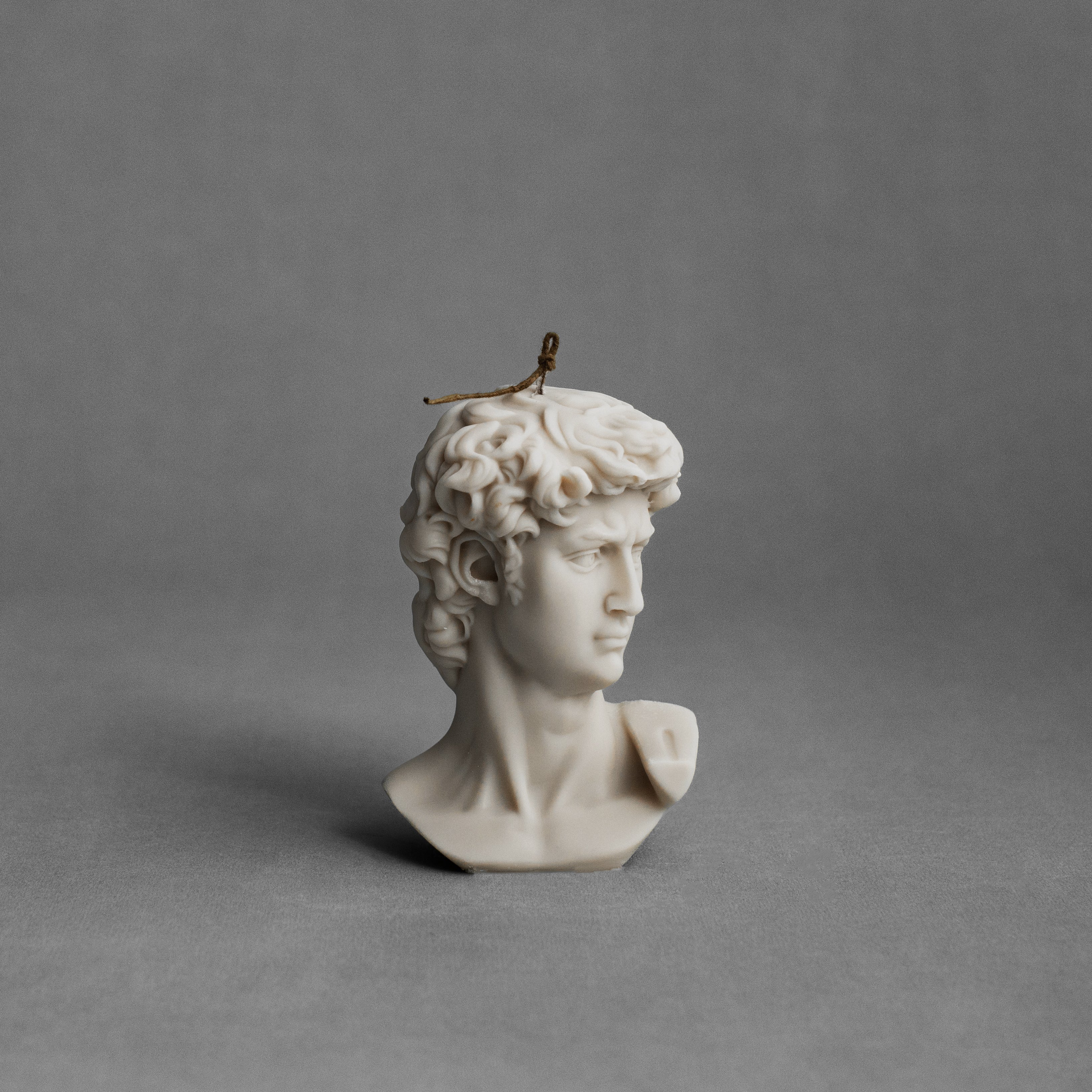 Moon gray David bust pillar candle by LAWA featuring classical sculptural detailing in soy wax