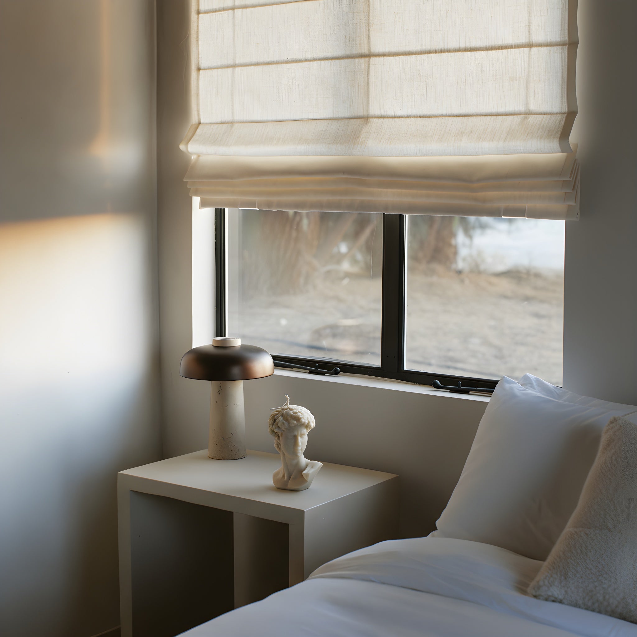 Bedroom with a window, a nightstand, and David Bust white candle on a bedside table