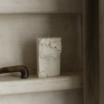 Handmade sculptural candle featuring half face design in soy wax on minimalist table setting in Los Angeles studio