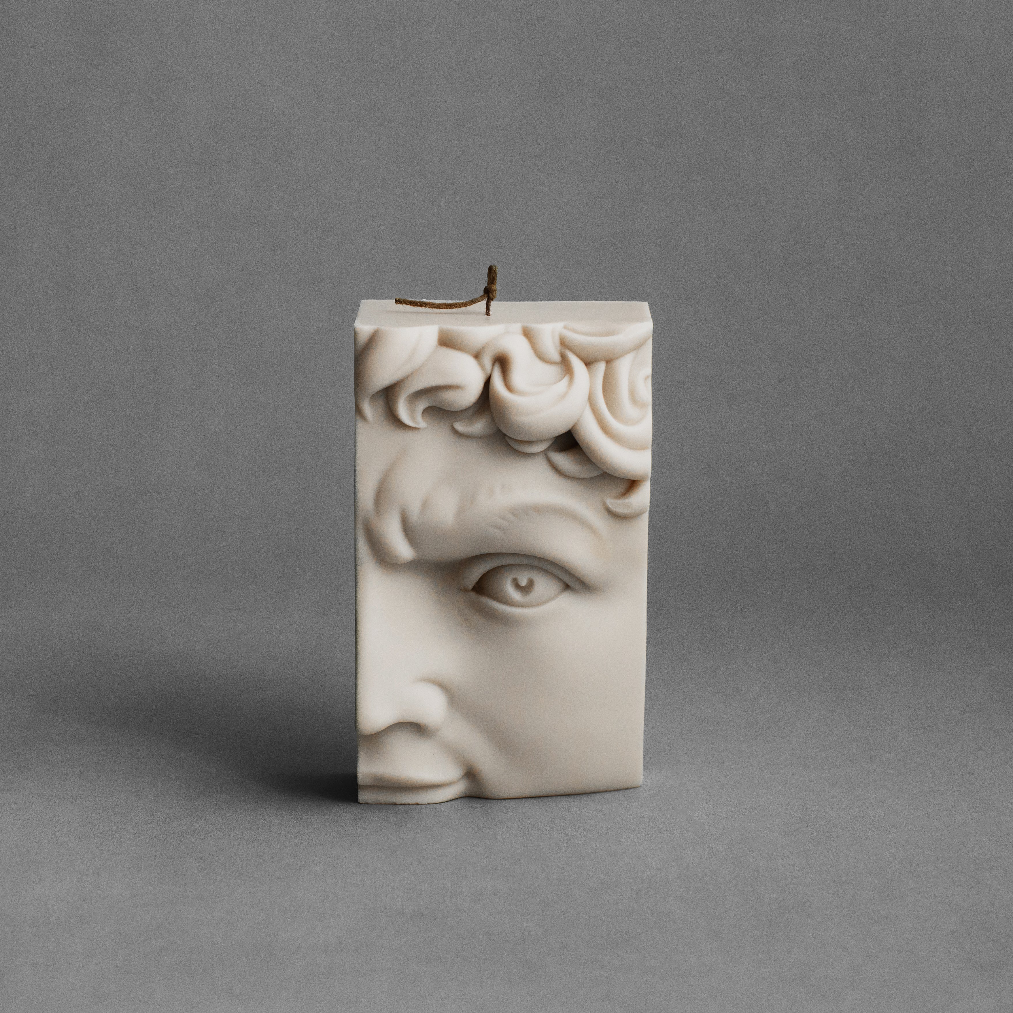Moon gray David half-face pillar candle by LAWA with sculpted classical details in soy wax