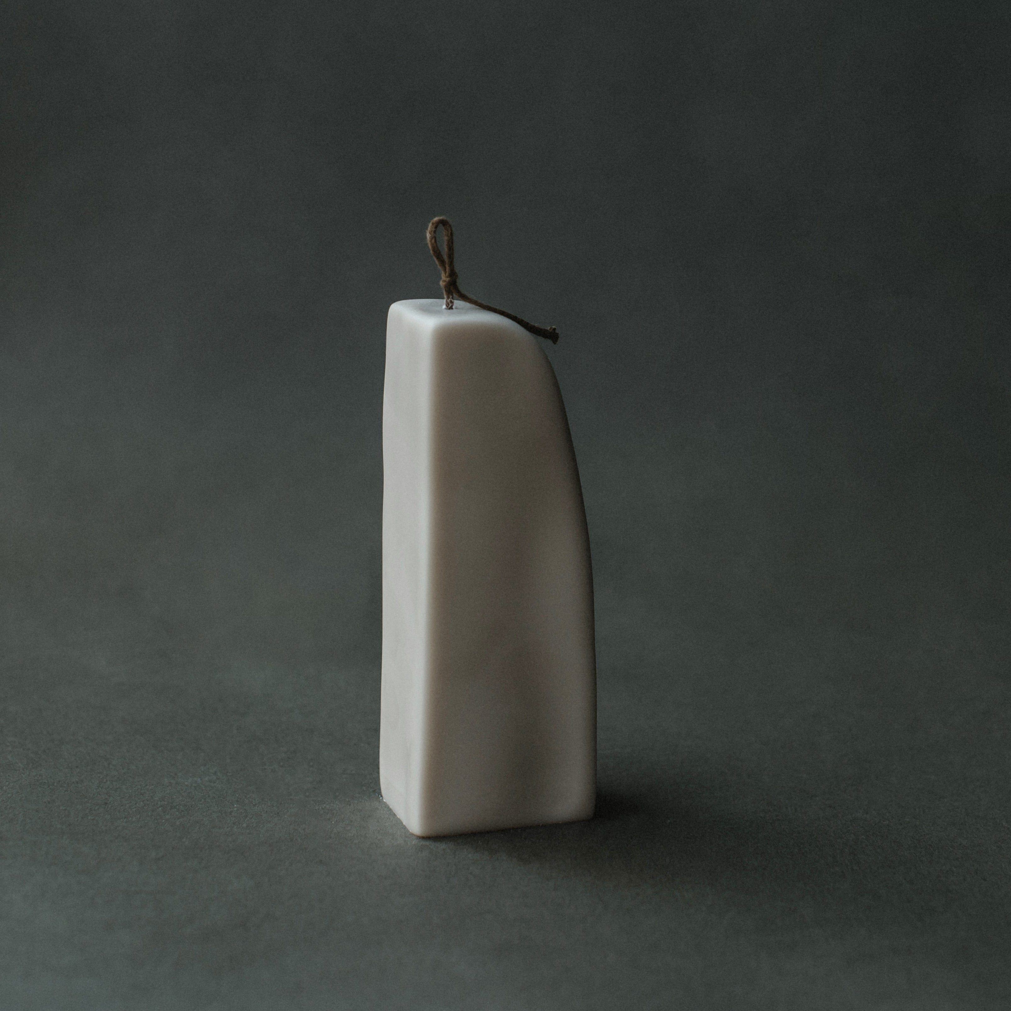 Light beige downhill sculptural soy wax candle by LAWA, modern minimalist decor piece with smooth curved form the view from the side