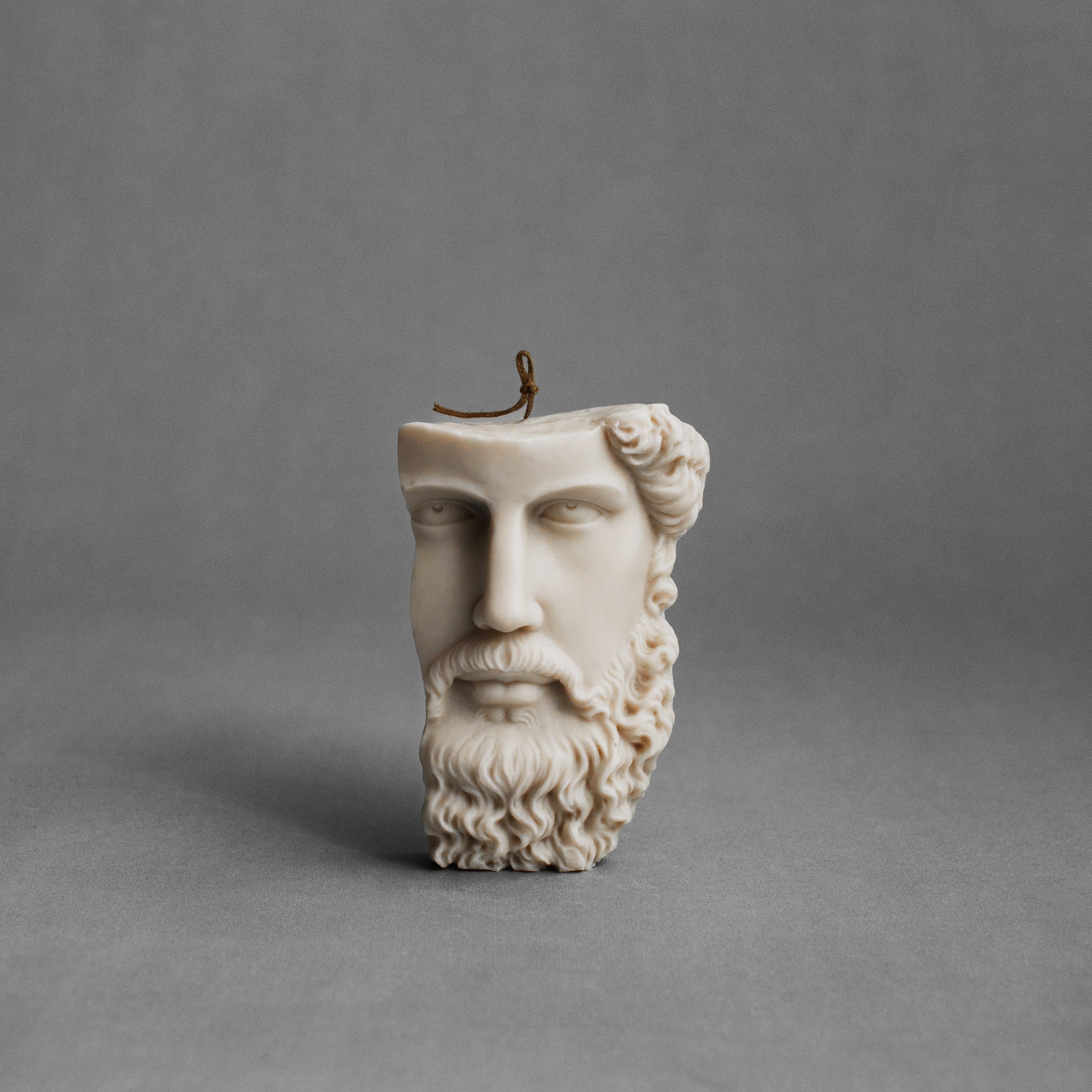 Moon gray Greek face pillar candle by LAWA with sculpted classical facial details in soy wax.