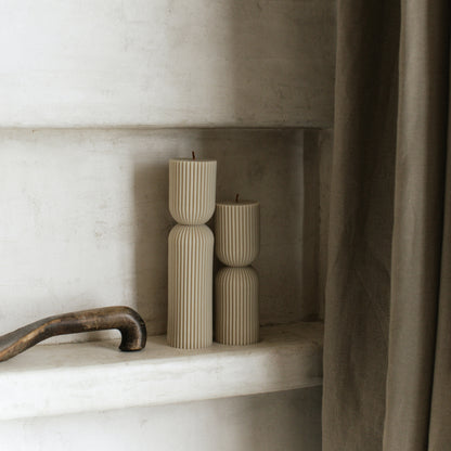 Close-up detail of handmade hourglass sculptural candle showing smooth soy wax texture and cotton wick