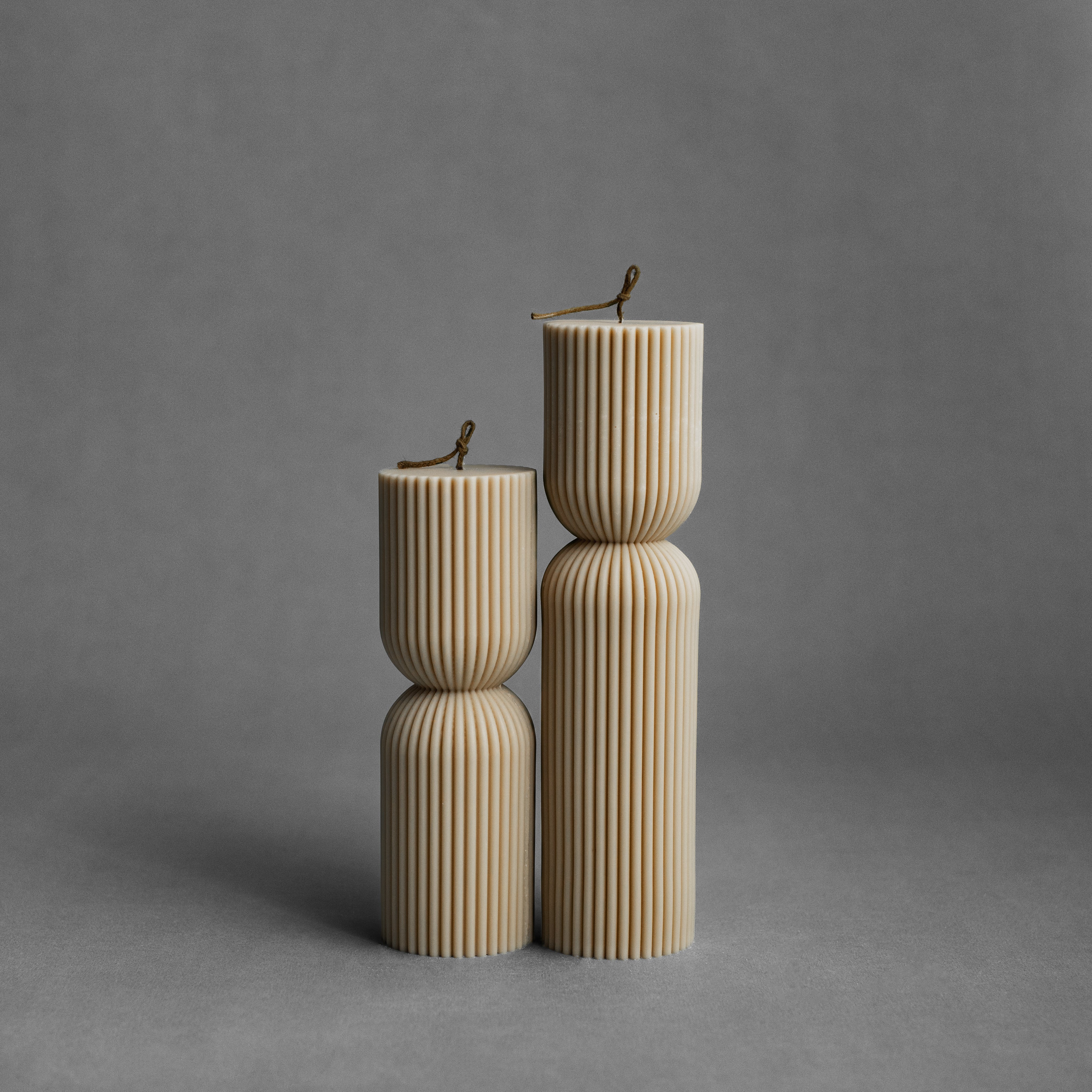 Sandstone hourglass pillar candle set by LAWA with warm curved silhouette