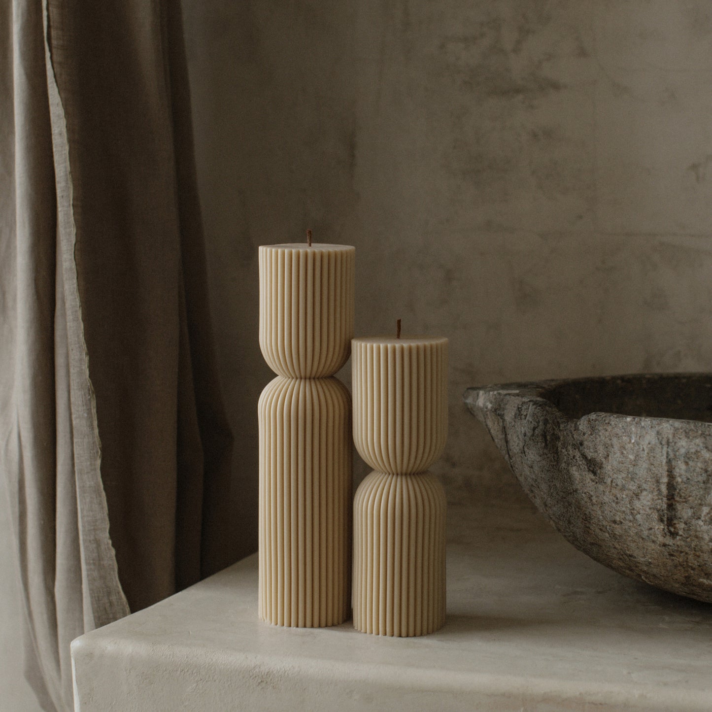 Close-up detail of handmade hourglass sculptural candle showing smooth soy wax texture and cotton wick