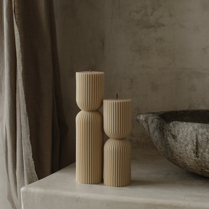 Close-up detail of handmade hourglass sculptural candle showing smooth soy wax texture and cotton wick