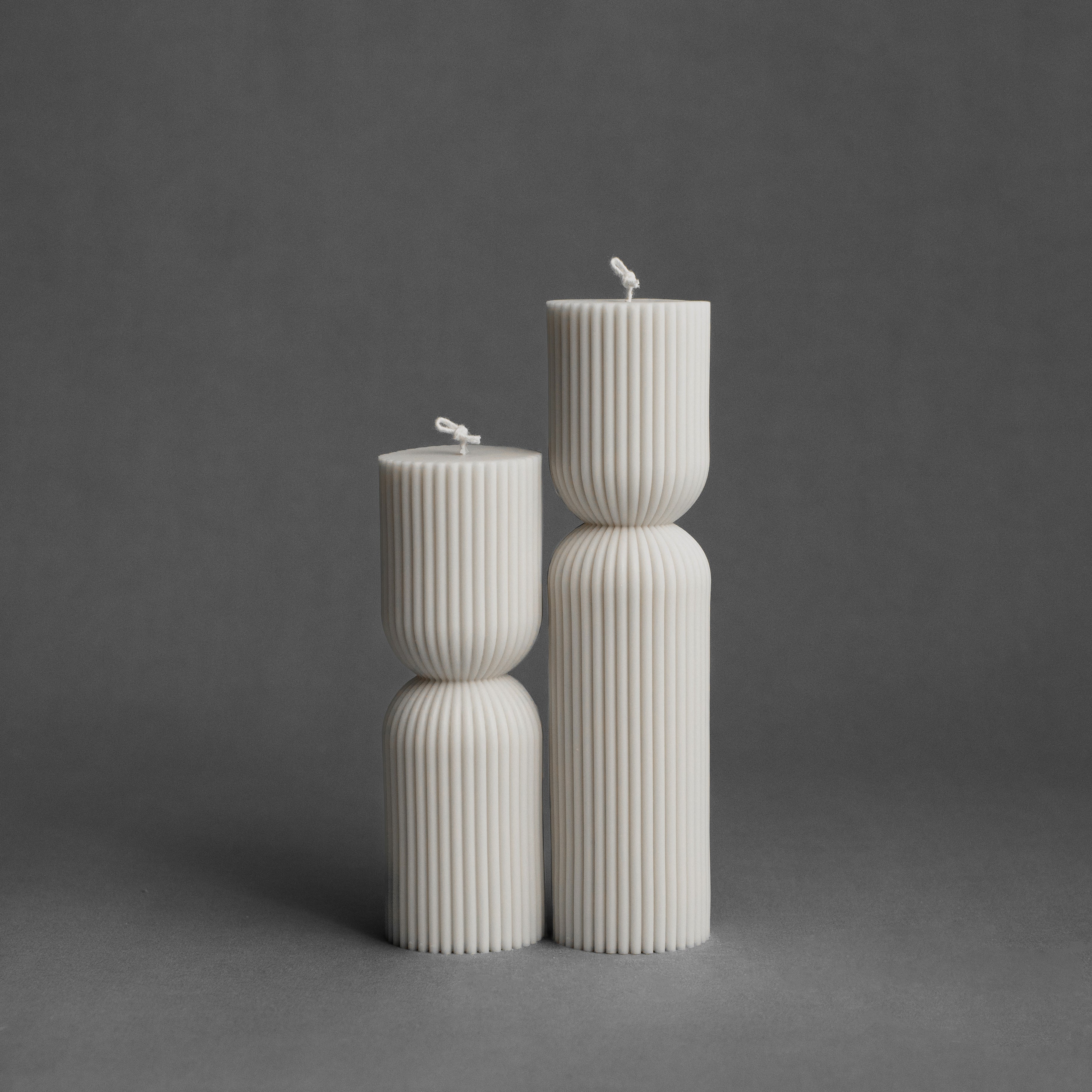 White hourglass pillar candle set by LAWA featuring sculptural curved silhouette