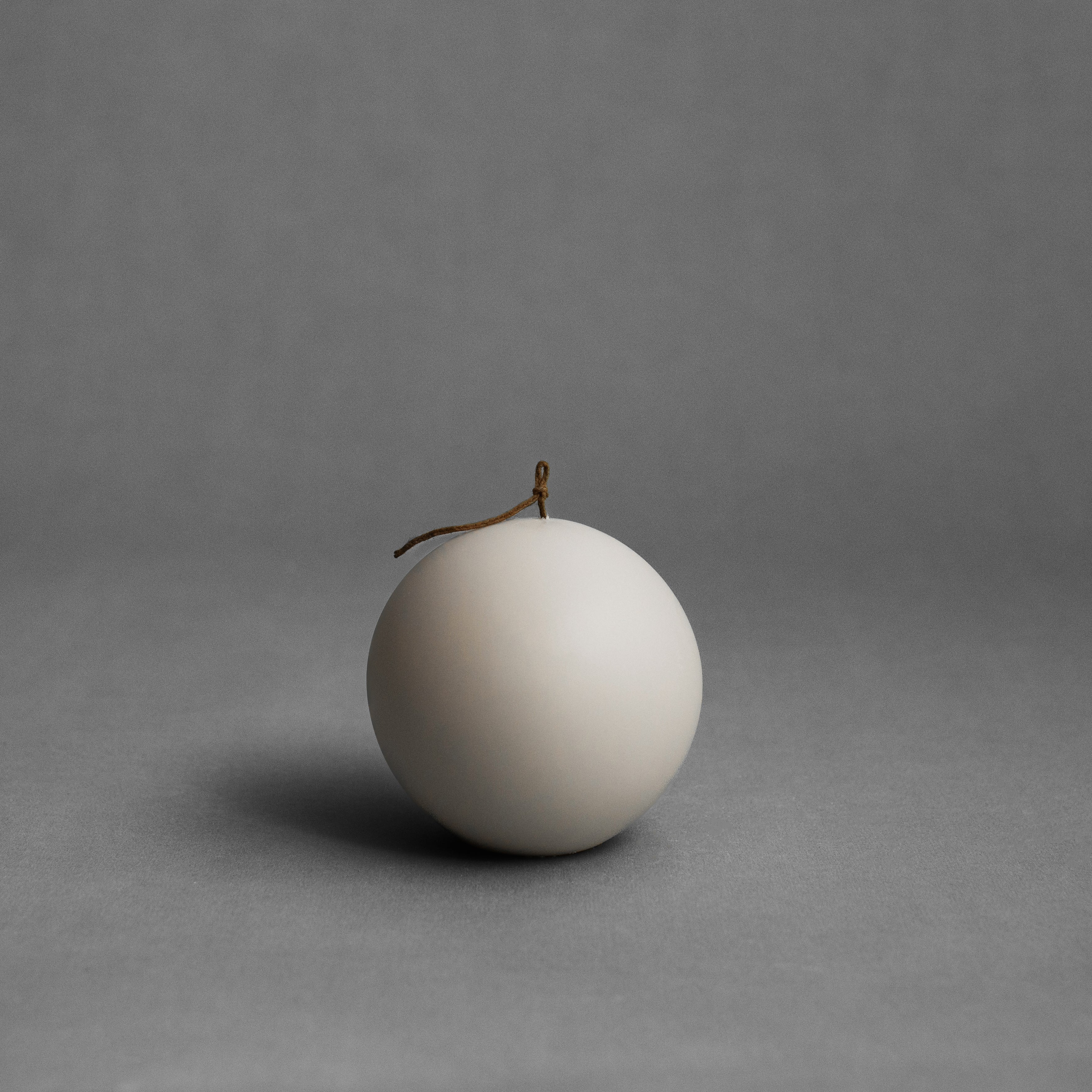 Large light beige sphere soy wax pillar candle by LAWA featuring a clean sculptural round design for modern interiors