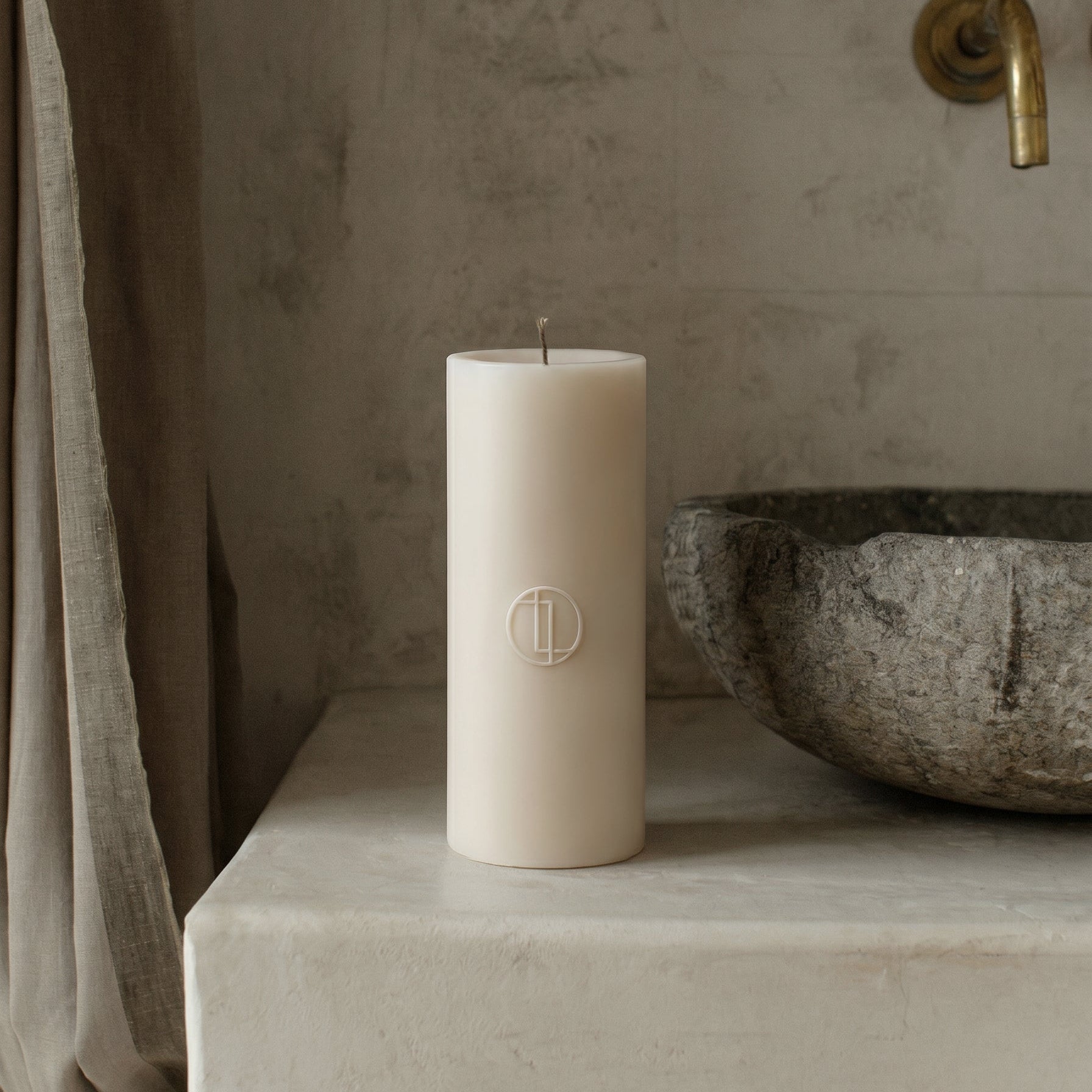 Unscented soy wax cylinder candle detail showing smooth handmade texture and cotton wick in minimalist setting