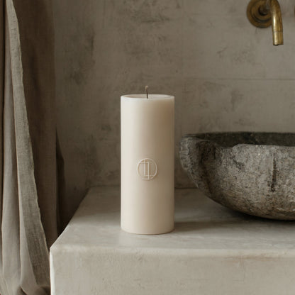 Unscented soy wax cylinder candle detail showing smooth handmade texture and cotton wick in minimalist setting